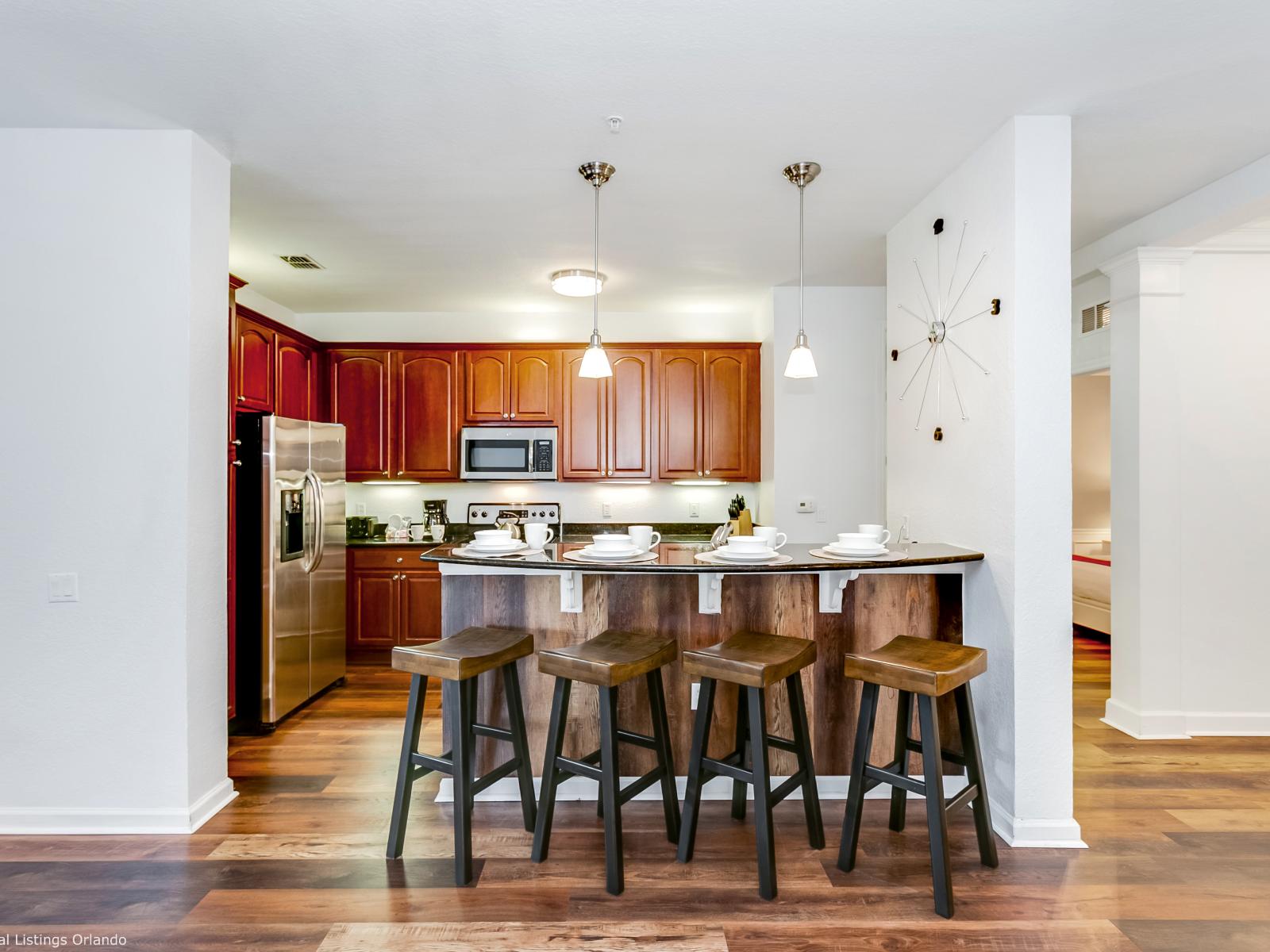 Luxurious open kitchen of the condo in Orlando -  Sufficient space to store goods - Availability of high chairs on the breakfast bar with elegant statement lighting - All necessary kitchen accessories are available - Plenty space to work with ease