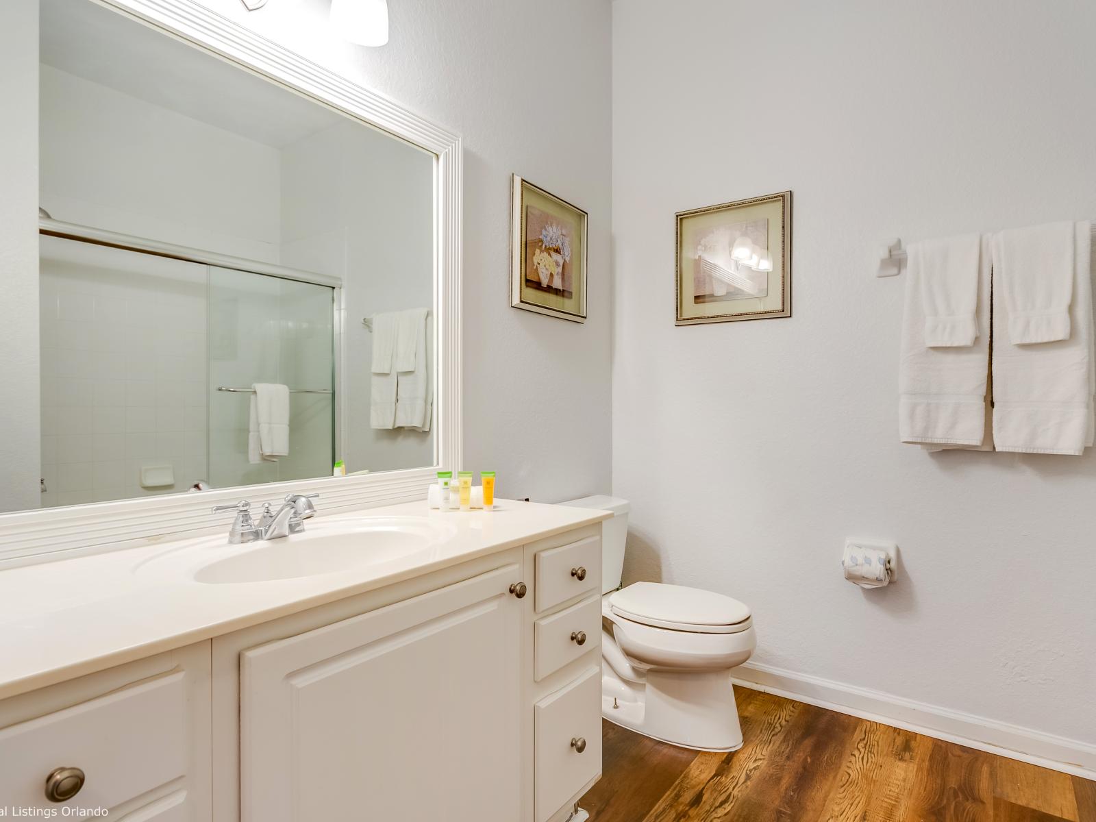 High-class bathroom of the condo in Orlando - A refreshing ambiance with a elegant decor - Neat and Cozy toilet seat - Glorious vanity with sufficient storage space and a big size wall mirror - Magnificently designed glass enclosed shower area