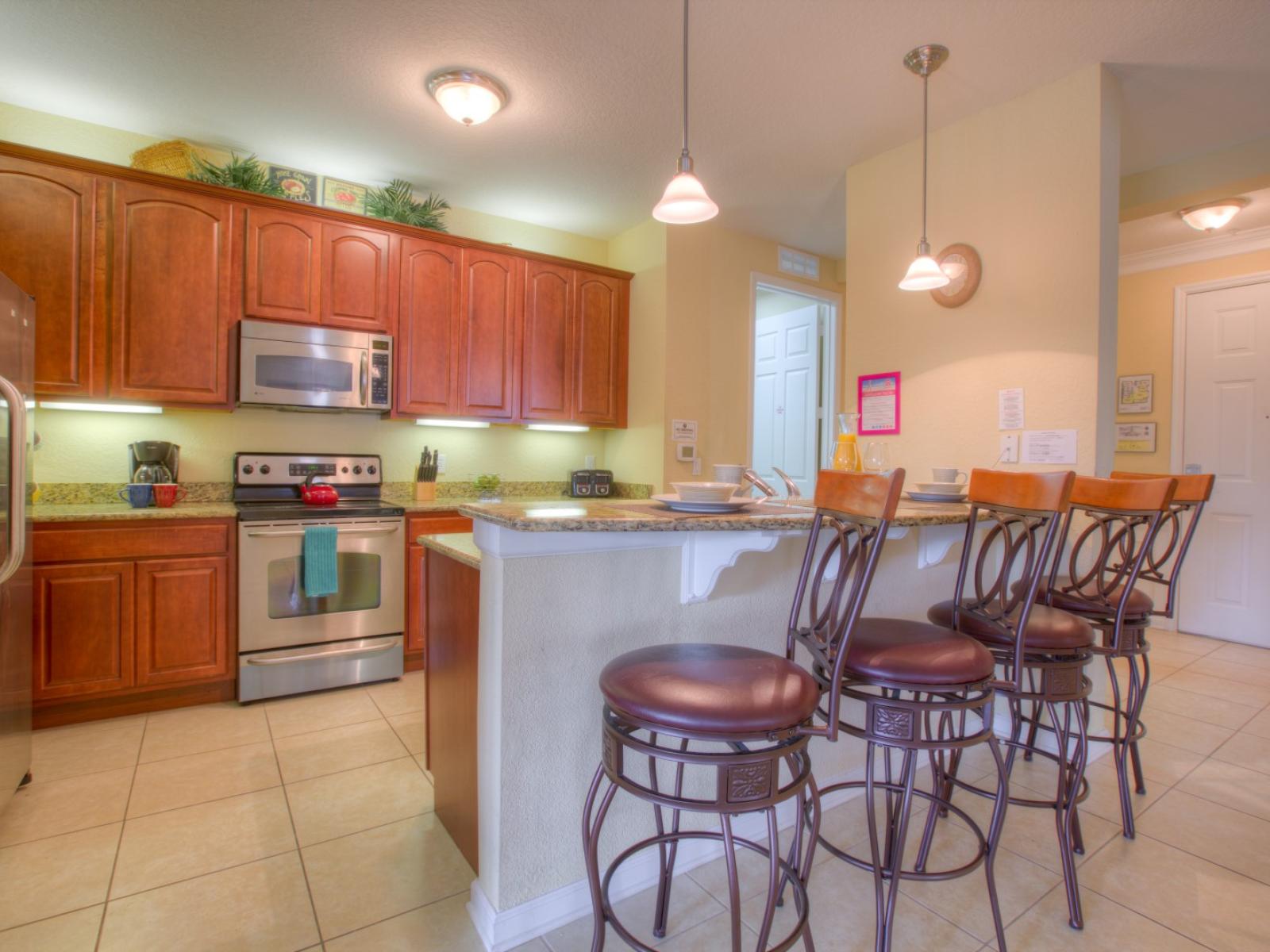 Lavishly designed fully equipped kitchen of the condo in Orlando - Availability of all necessary kitchen accessories - Elegant lighting - Plenty storage space to store goods - Availability of high chairs at the breakfast bar