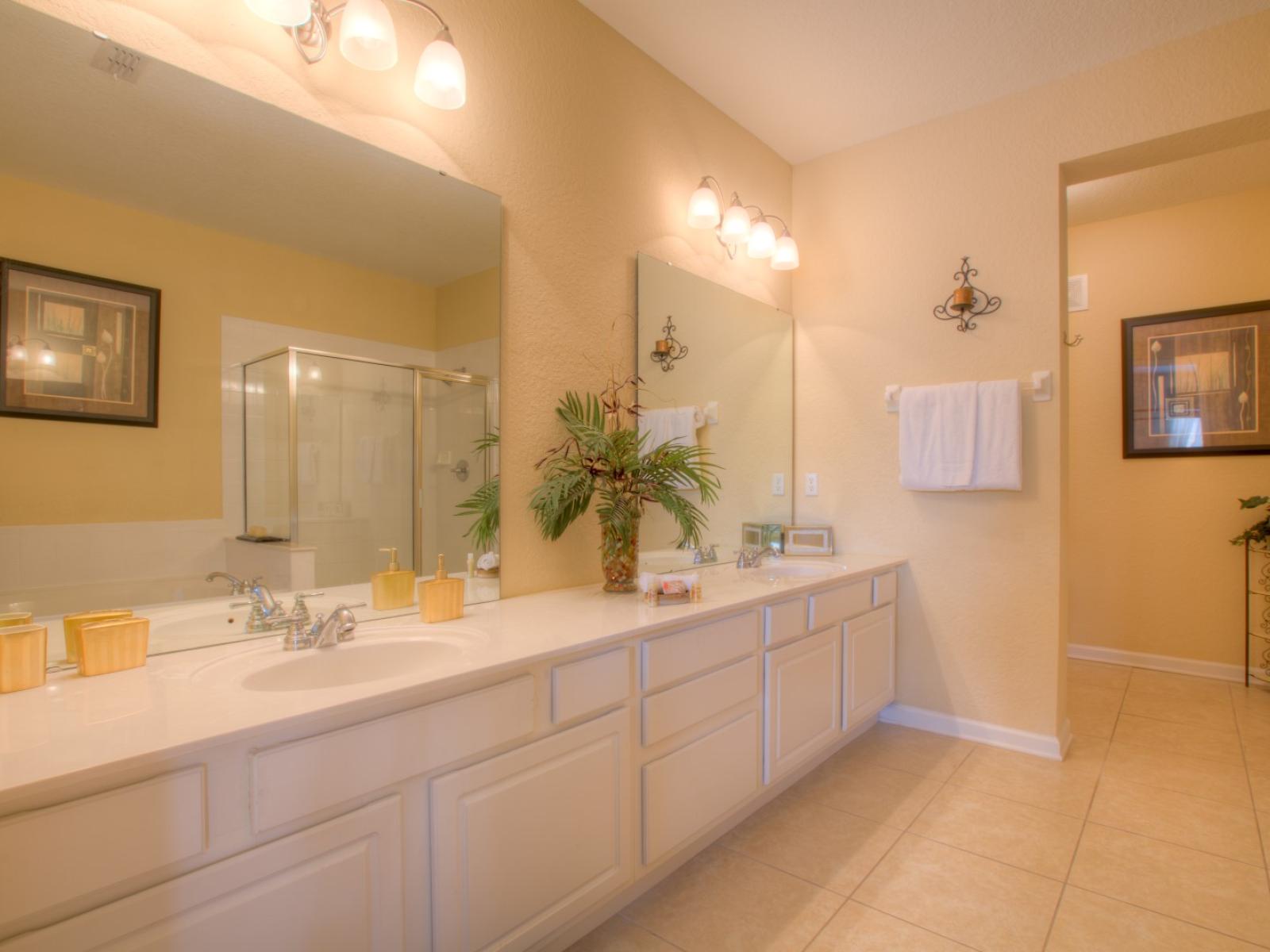 Exclusive Bathroom of the condo in Orlando - Lavishly designed bathroom with beautiful vanity - Large size wall mirror with magnificent wall lamps - Sufficient storage space - Availability of Fresh towels -  Neat and clean toilet seat