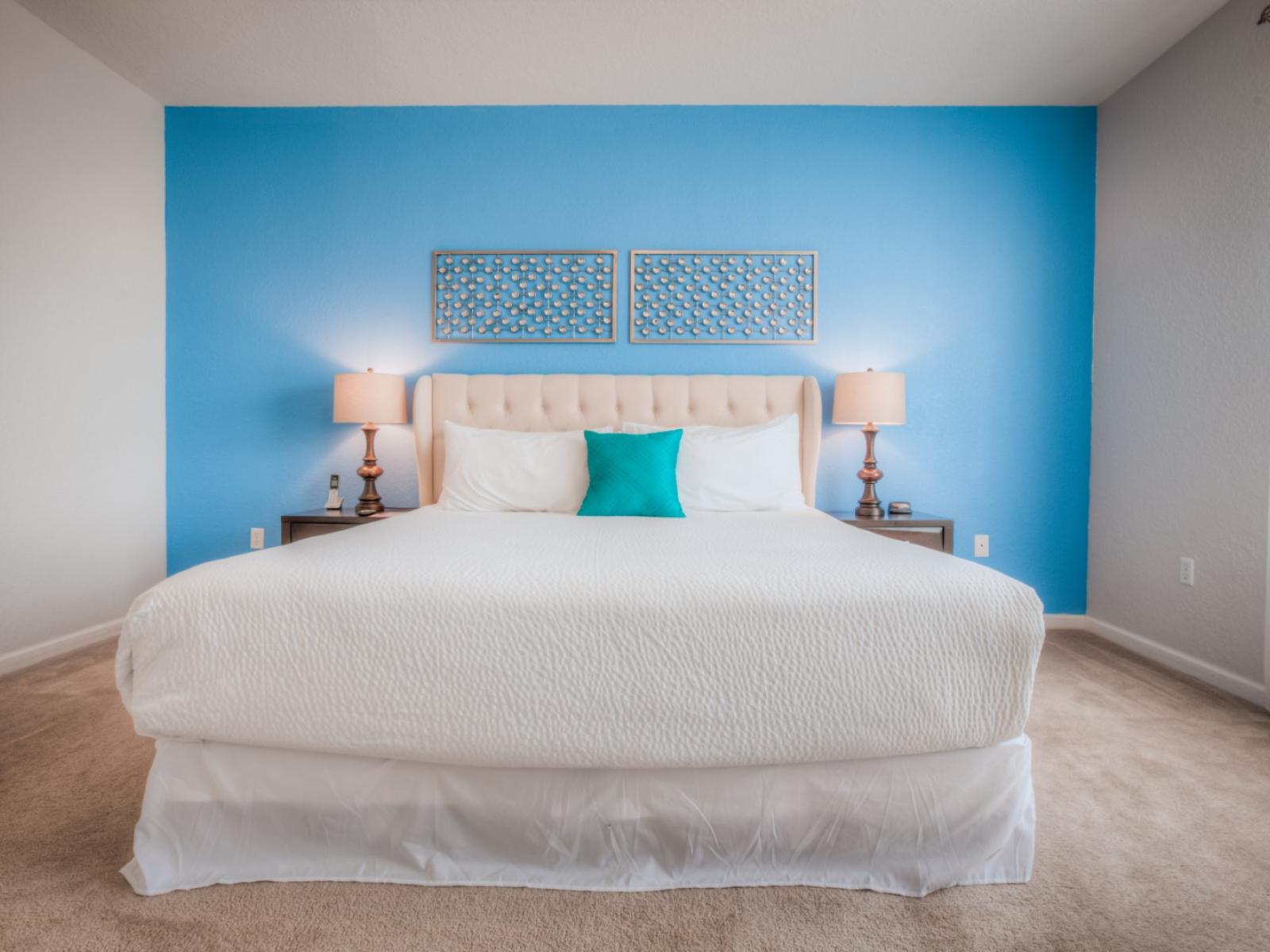 Exquisite bedroom of the condo in Orlando - Features a calming blue accent wall and a cozy double bed with neat and clean linen  - Inviting to unwind and recharge in a soothing oasis of comfort and style. - Bright and airy window with lovely views