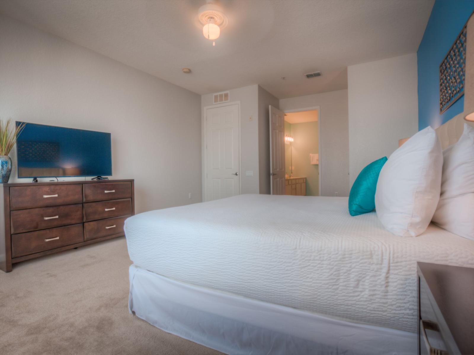 Relax in style in this bedroom at Vista Cay Resort, complete with a TV for your viewing pleasure, offering the perfect escape for unwinding after a day of adventure in Orlando's vibrant surroundings.