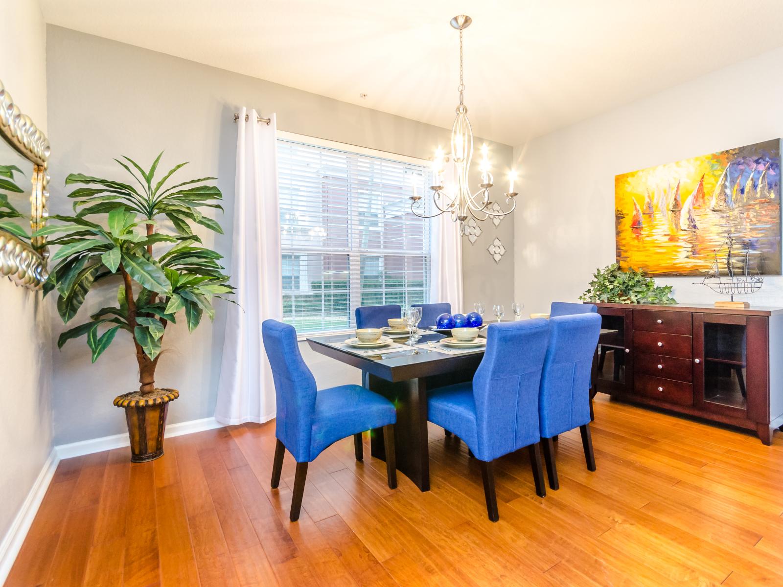 The  elegant six-seater dining table, complemented by comfortable chairs and a captivating chandelier casting vibrant lighting. Every meal is a celebration of comfort, elegance, and cherished moments shared together.