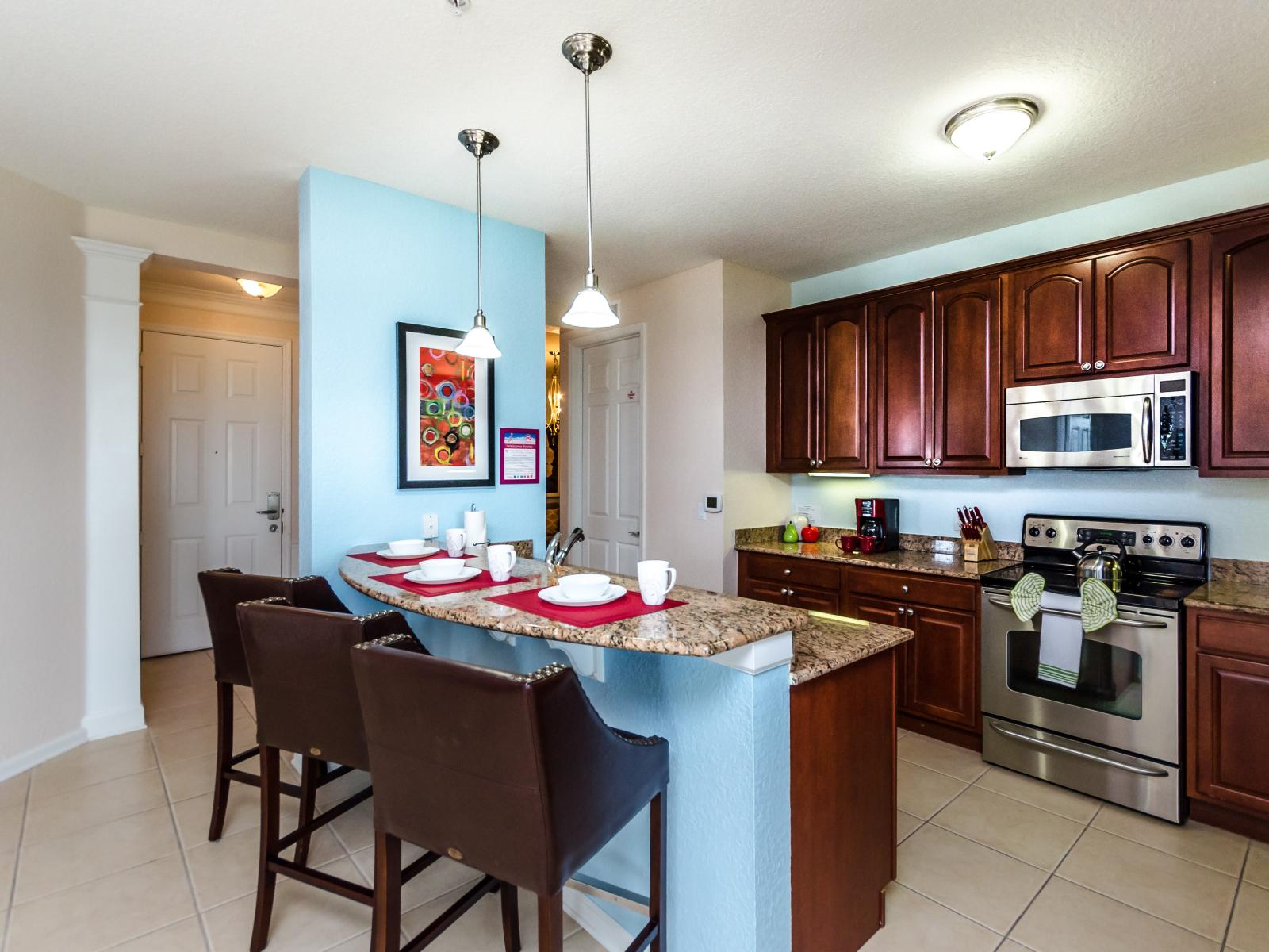 Luxurious and thoughtfully designed Kitchen of the condo in Orlando - Fully equipped with all necessary kitchen amenities - Plenty space to store goods - Availability of high chairs at breakfast bar with focus lamps