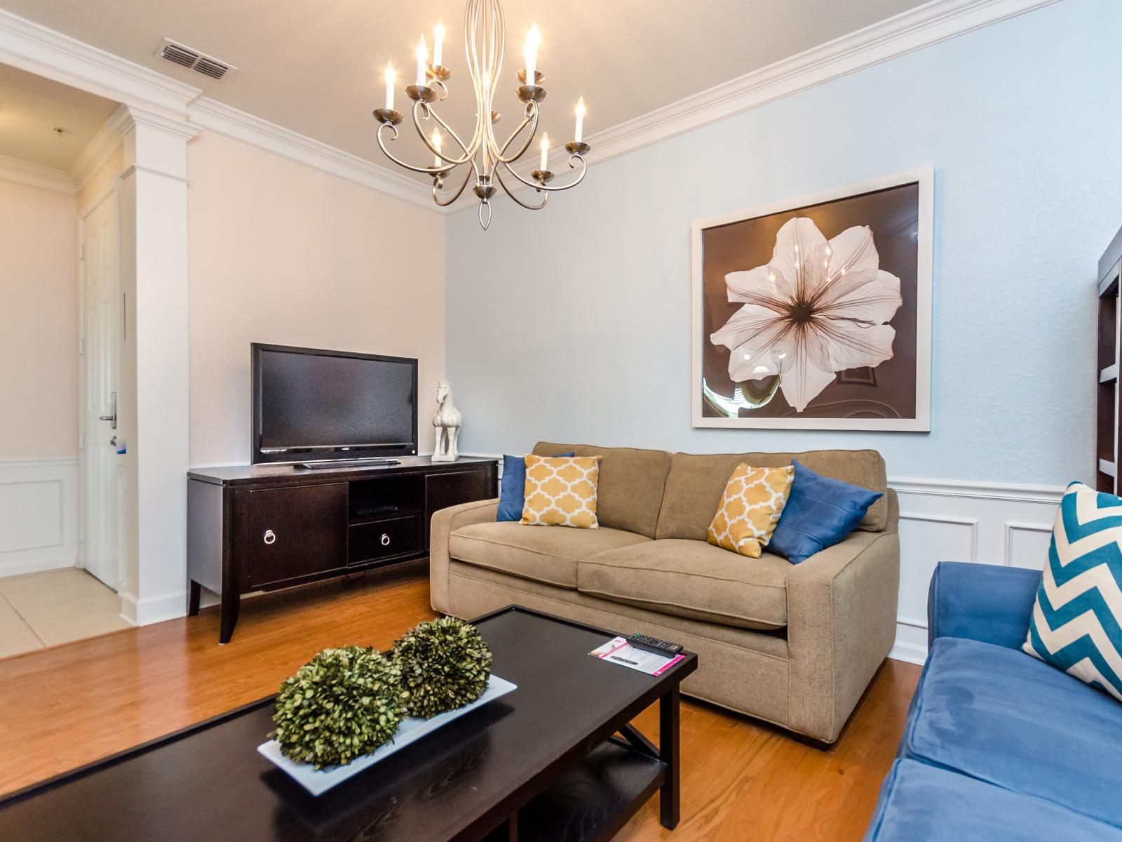 Sublime living area of the condo in Orlando - Comes with cozy sofas ensuring a relaxing environment - Decored with big wall paintings - Glamorous Chandelier creating an elite aroma in well designed living area - Entertain yourself with smart TV