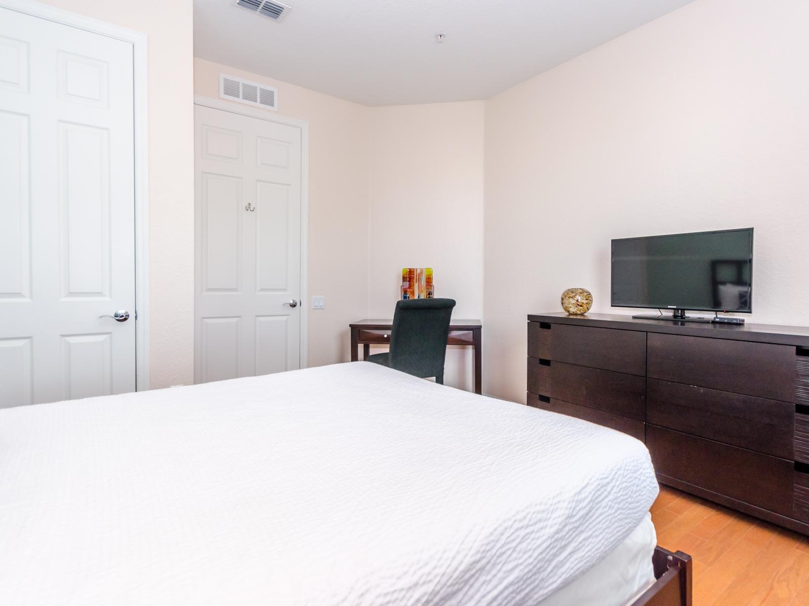 Modern bedroom of the condo in Orlando - With sleek design this bedroom offers a cozy bed - For Entertainment Smart Tv is available - Spaciously utilized corner of the bedroom for a dedicated work station - Glorious wooden furnishing