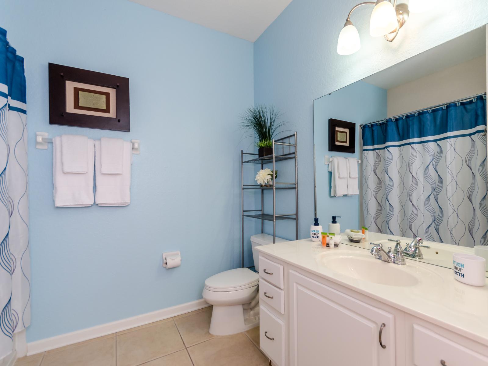 Classy bathroom of the condo in Orlando - Neat and clean cozy toilet seat - Marvelous vanity with large wall mirror and plenty of storage space - Fresh towels and all bathroom amenities available - Amazing walk-in shower area with sliding curtains