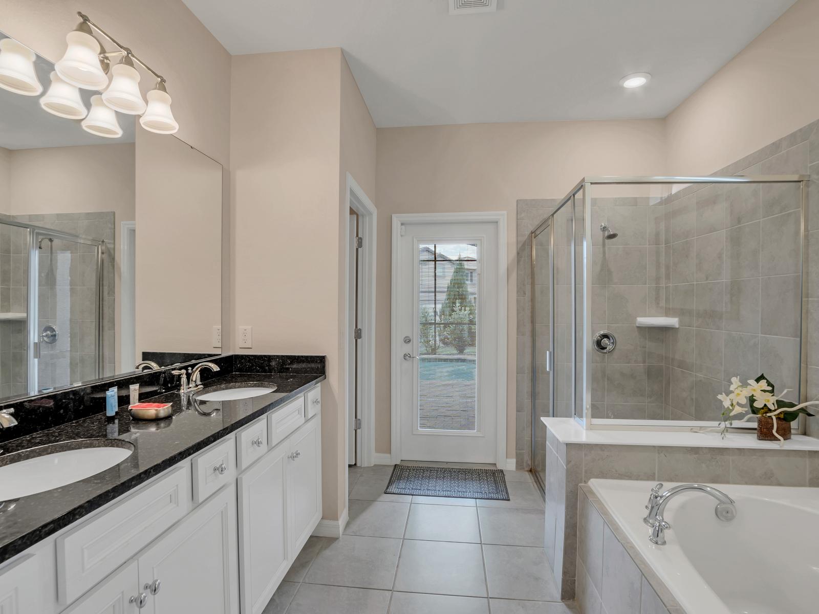 Polished bathroom of the home in Davenport Florida - Elegant bathroom with luxurious fixtures and finishes - Chic design featuring a sleek vanity and upscale lighting - Glass-enclosed spacious shower stall