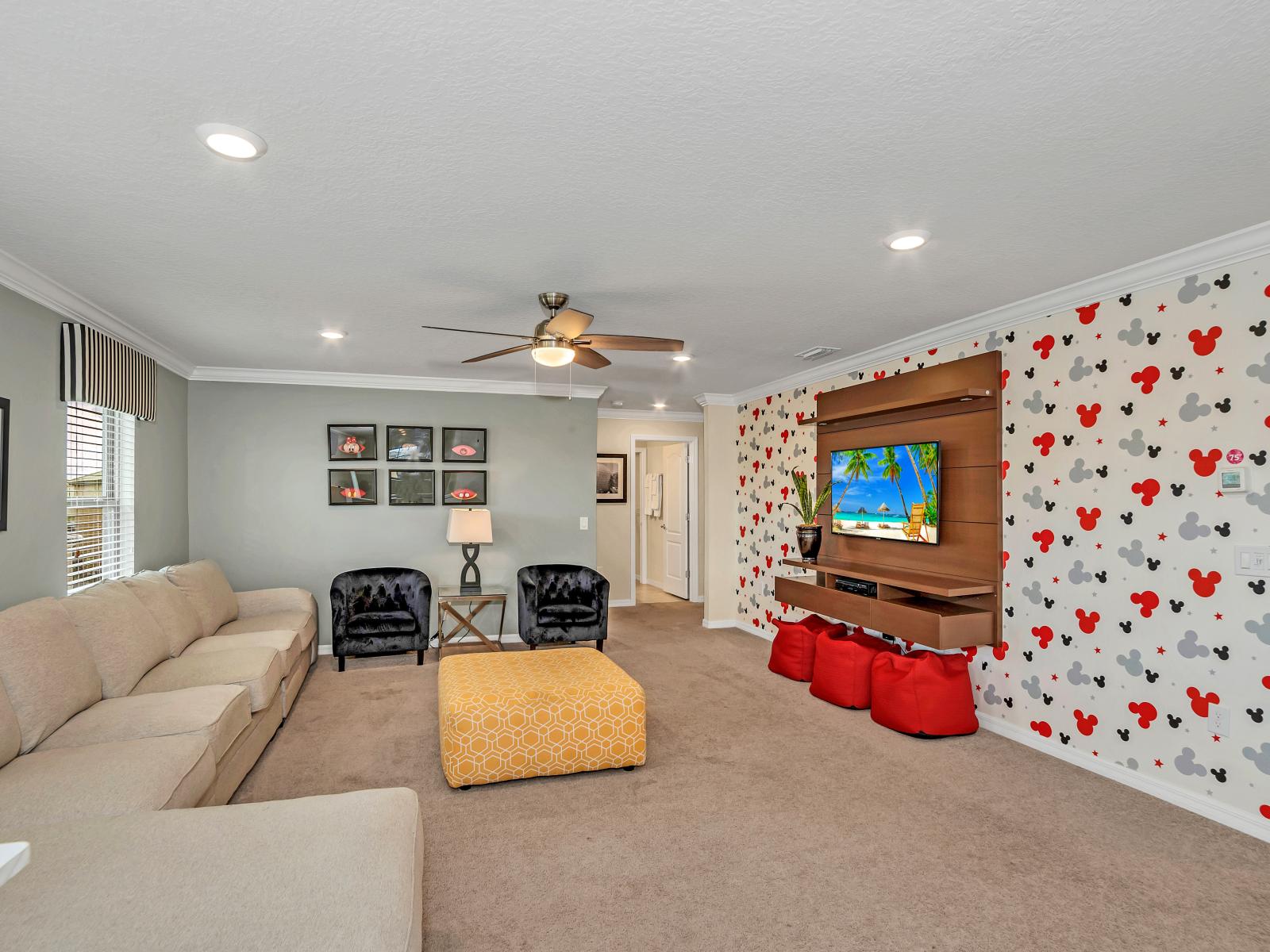 Enchanting living area of the home in Davenport Florida - Beautiful mickey mouse accent wall - Plush sofa for relaxation - Well-chosen lighting fixtures adding both functionality and charm