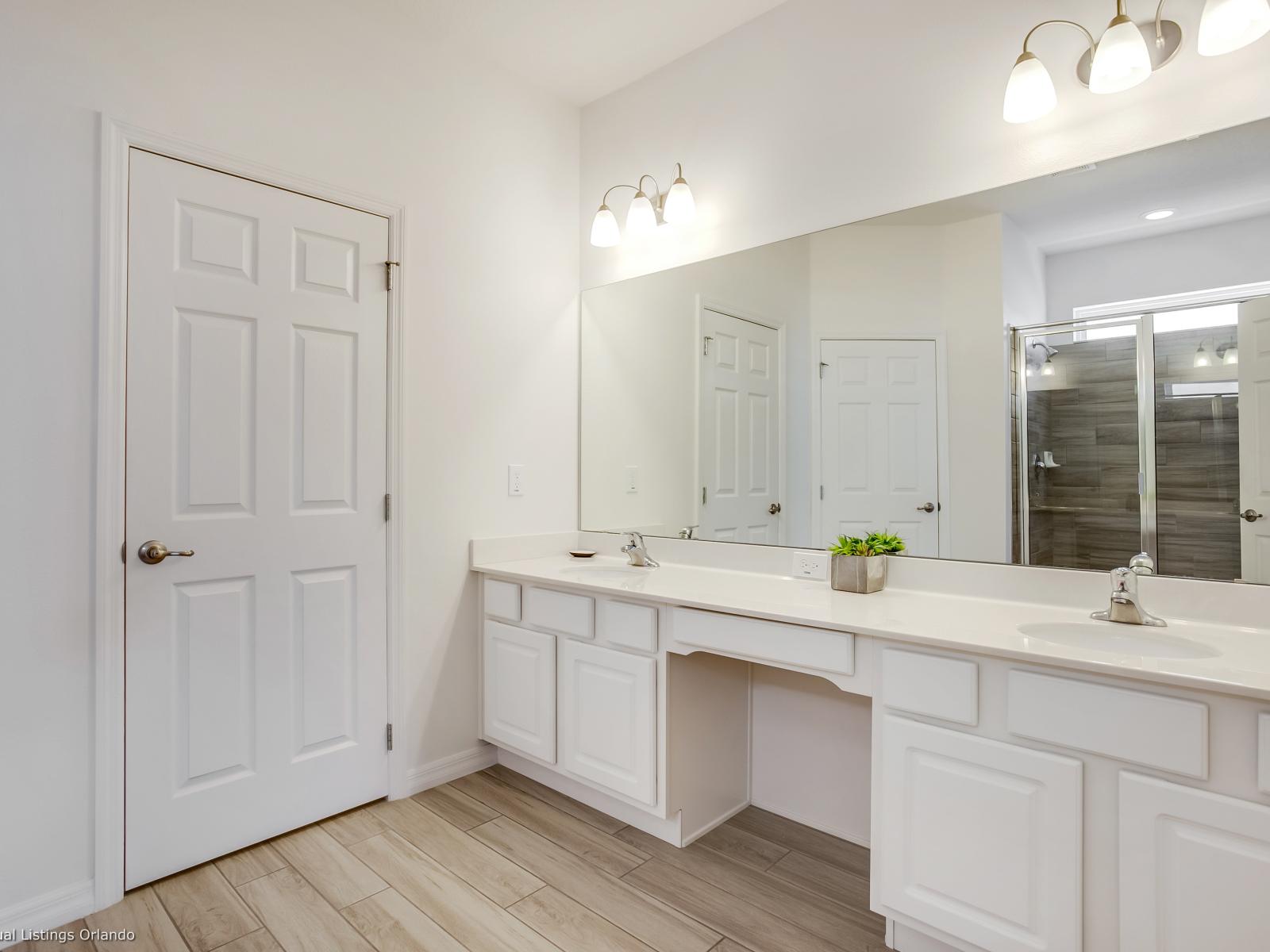 Well-lit bathroom of the Villa in Florida - Lush Double Vanity with full size mirror - Attention to detail, from the elegant tiles to the faucets - Inviting ambiance with soft, ambient lighting and tasteful decor