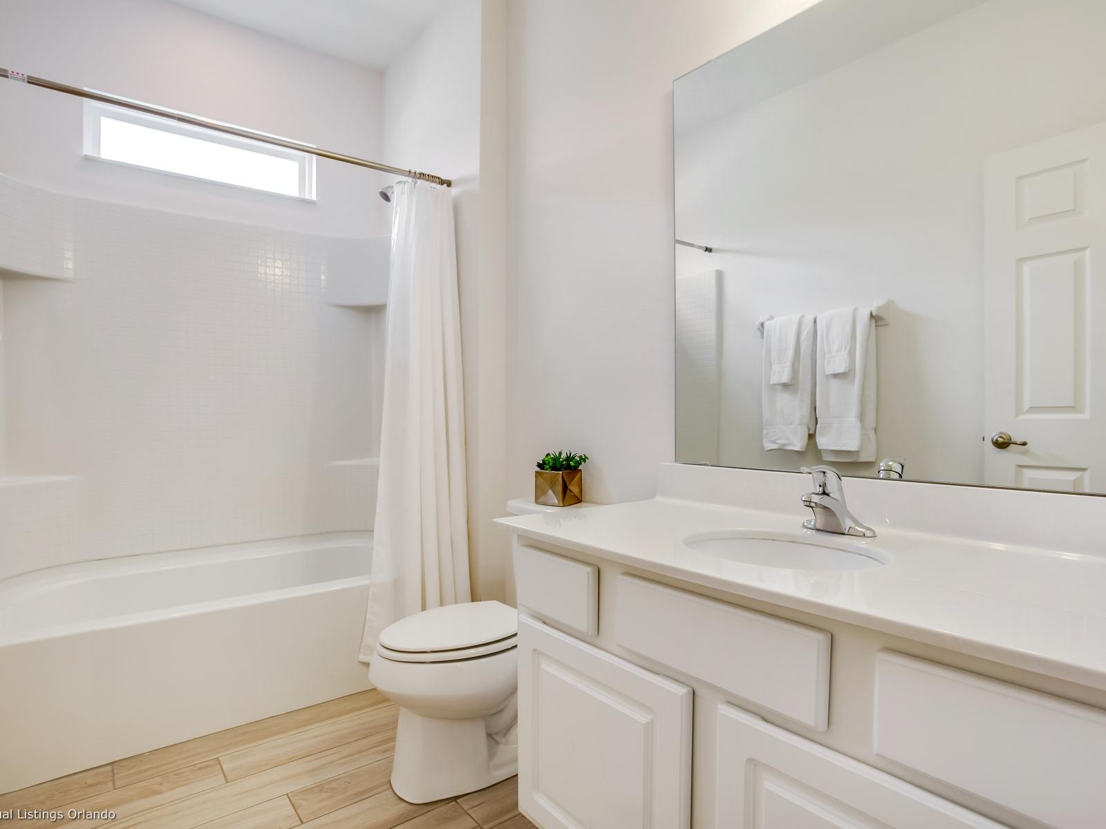 Lavish Bathroom of the Villa in Florida  - Chic design featuring a sleek vanity and upscale lighting - Seamless design featuring a glass-enclosed shower - Spacious layout offering a sense of luxury and comfort