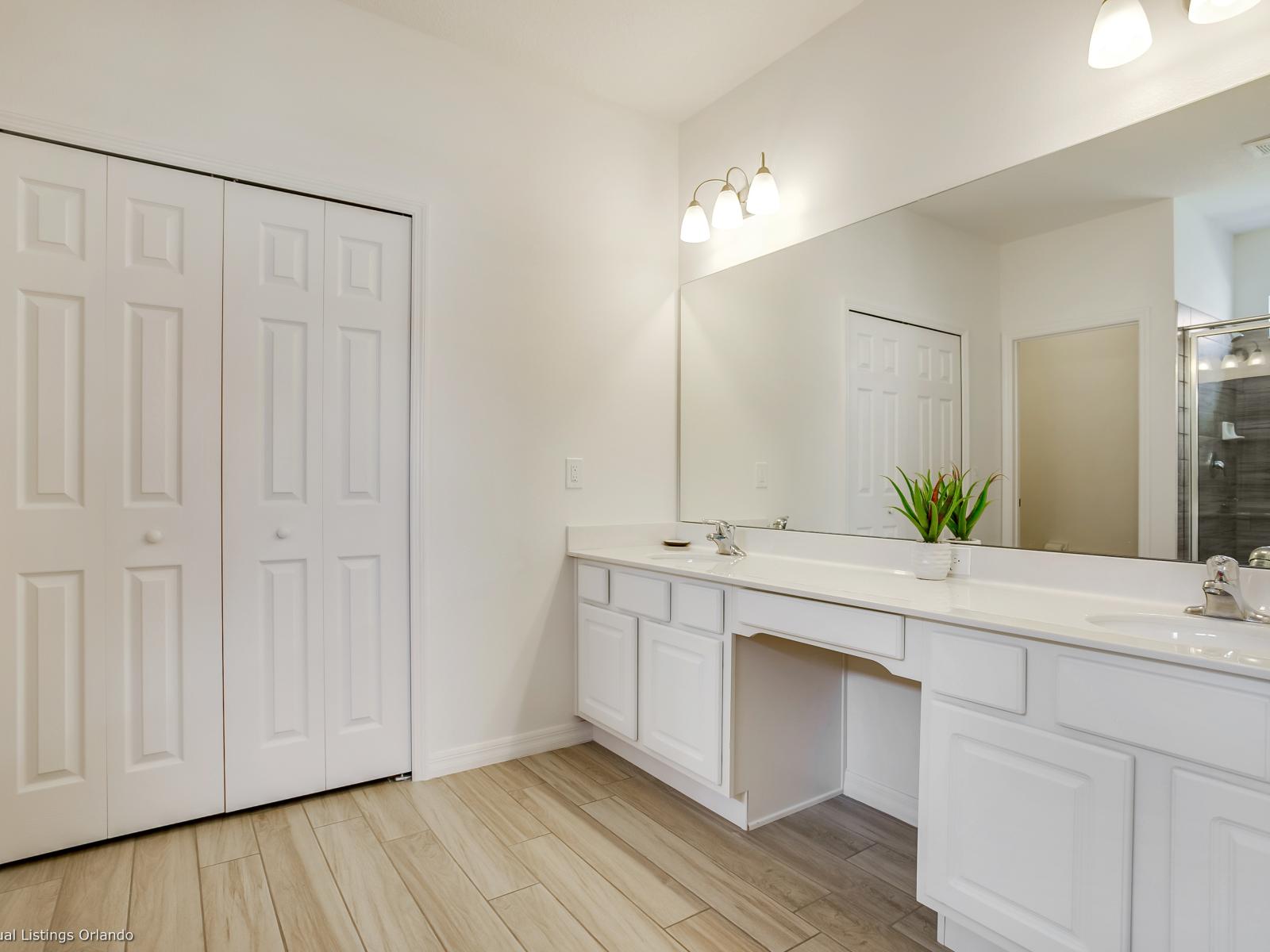 Eclat Bathroom of the Villa in Florida - Chic vanity with large Mirror - Glass enclosed Shower Area for modern feel - Sophisticated color palette creating a serene ambiance