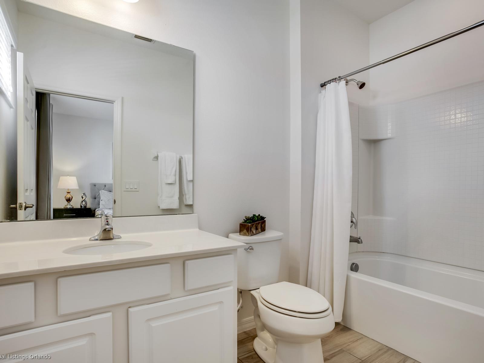 Eclat Bathroom of the Villa in Florida - Chic vanity with large Mirror - Glass enclosed Shower Area for modern feel - Sophisticated color palette creating a serene ambiance