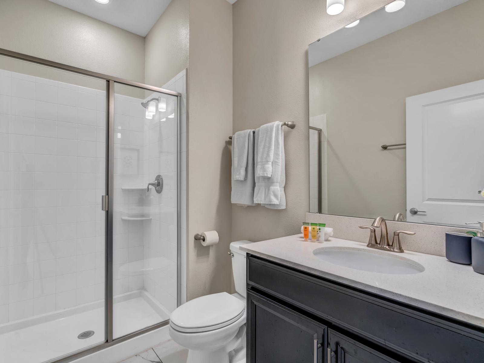 Chic Bathroom of the Townhouse in Kissimmee Florida - Chic Vanity with large mirror - Experience Pure Comfort - Featuring a Spacious Walk-In Shower