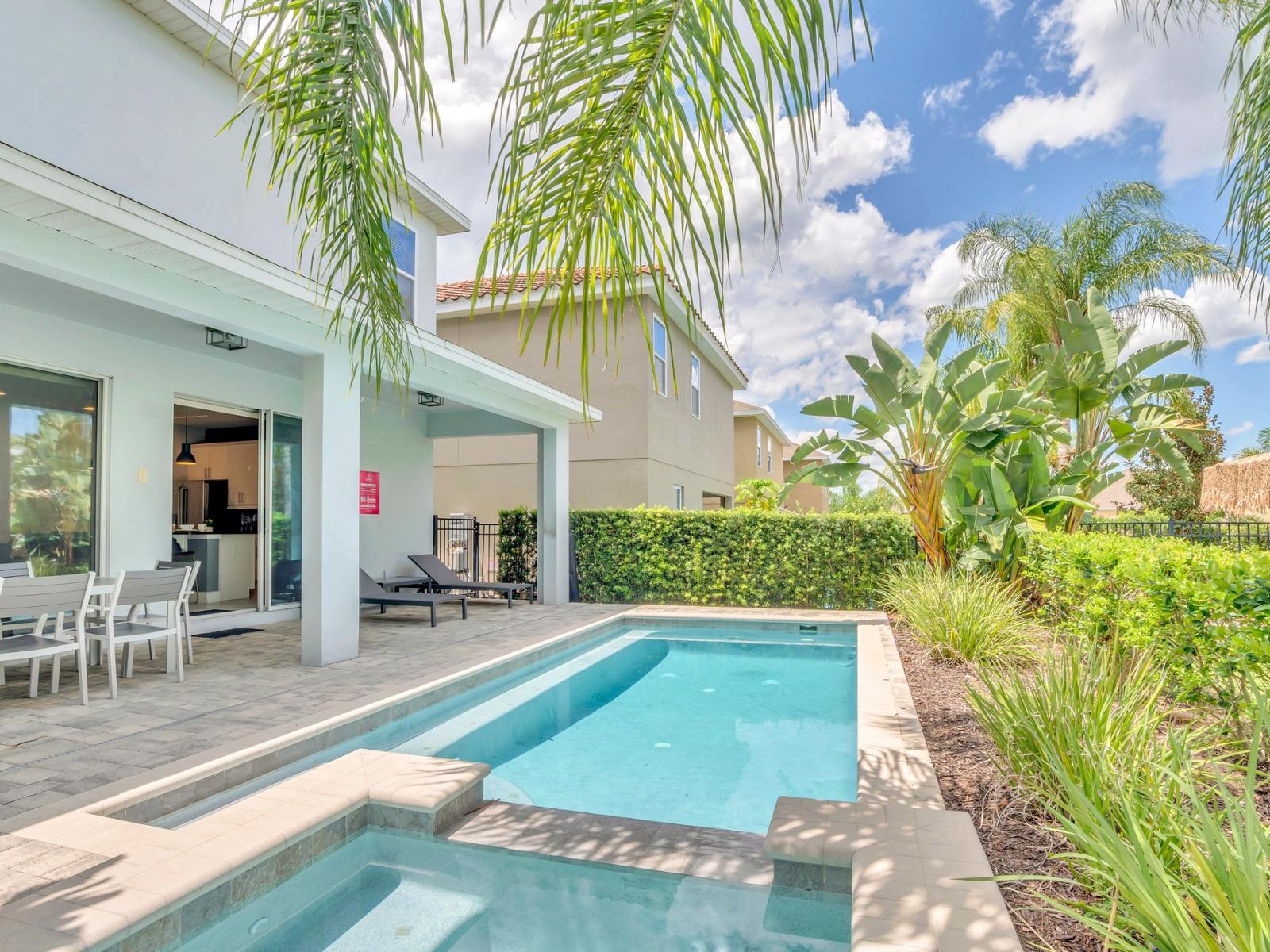 Stunning Pool Area of the Apartment in Kissimmee Florida - Tranquility by the sparkling water - Immerse yourself in the cool elegance - Discover bliss by the pool in serene setting - Palm trees and tropical plants enhance the vacation feel