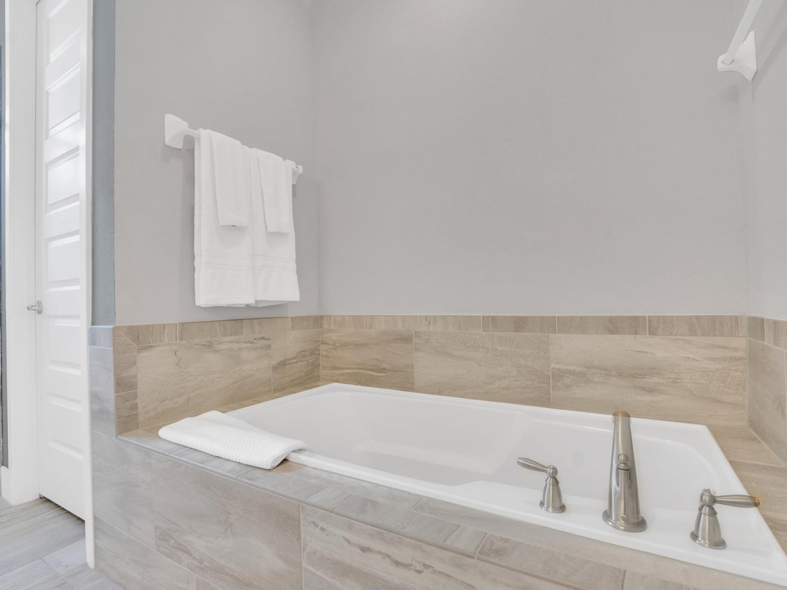 Elegance Unveiled: Immerse yourself in sophistication in our ensuite bathroom, designed with a luxurious bathtub and a chic walk-in shower for the utmost indulgence.