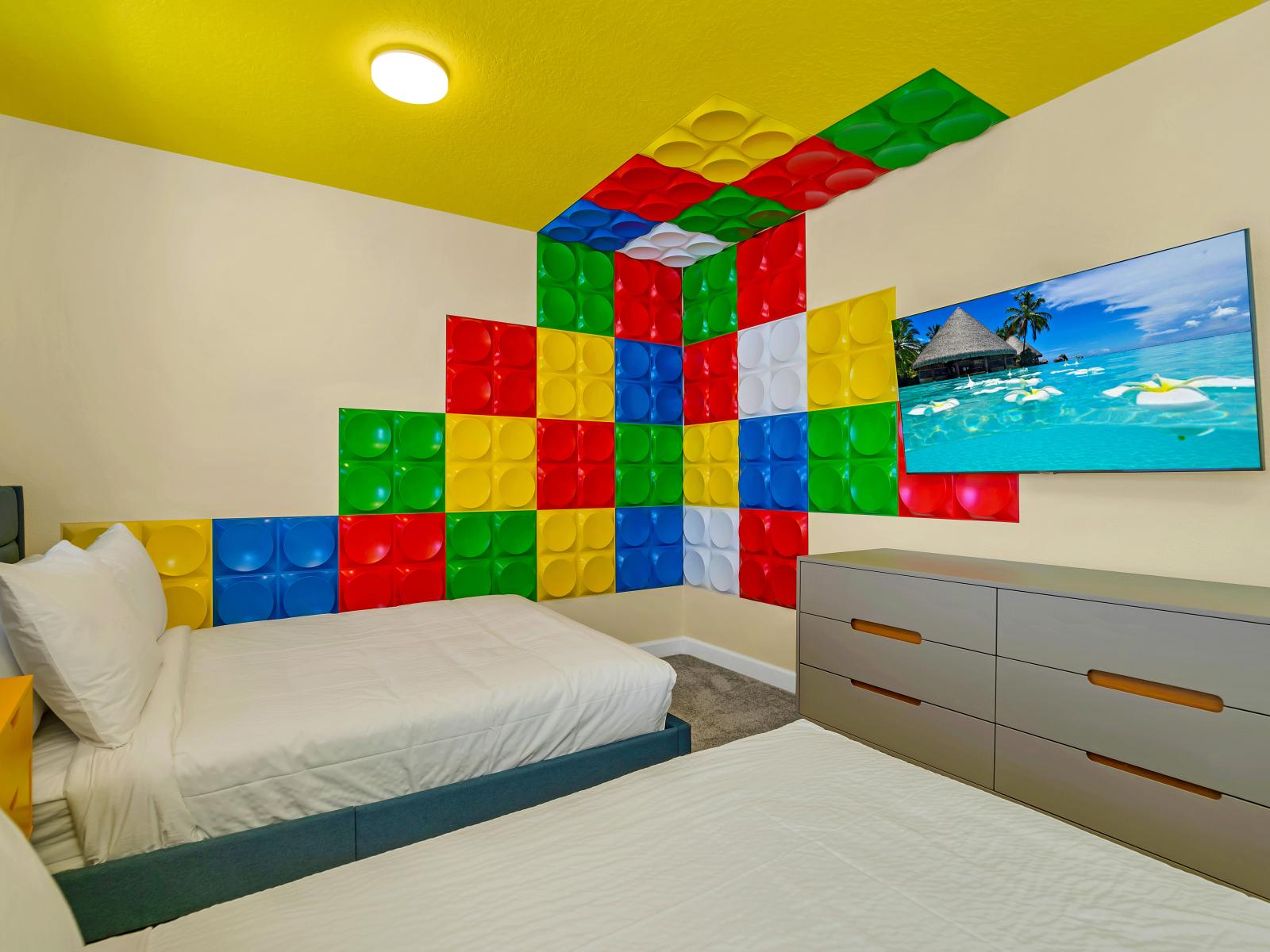 Three beds, a large dresser, and a colorful puzzle-piece wall makes this one of the coolest rooms in the entire house!