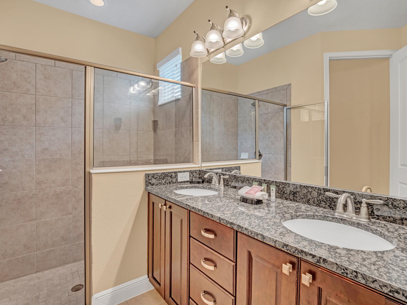 Lush Bathroom of the Home in Kissimmee Florida - Modern Walk-in Shower Area - Luxe double vanity with large mirror - Elegant bathroom with luxurious fixtures and finishes