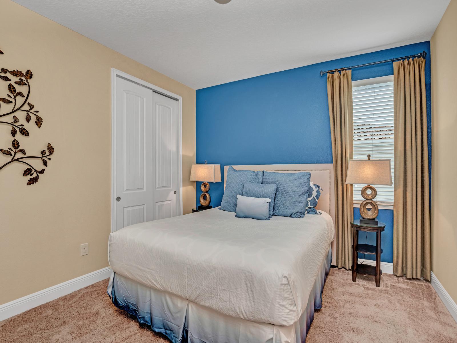 Impressive Bedroom of the Home in Kissimmee Florida - Step into tranquility in this bedroom with a striking blue accent wall  - Soothing hues evoke serenity and style, creating a space that's both refreshing and inviting