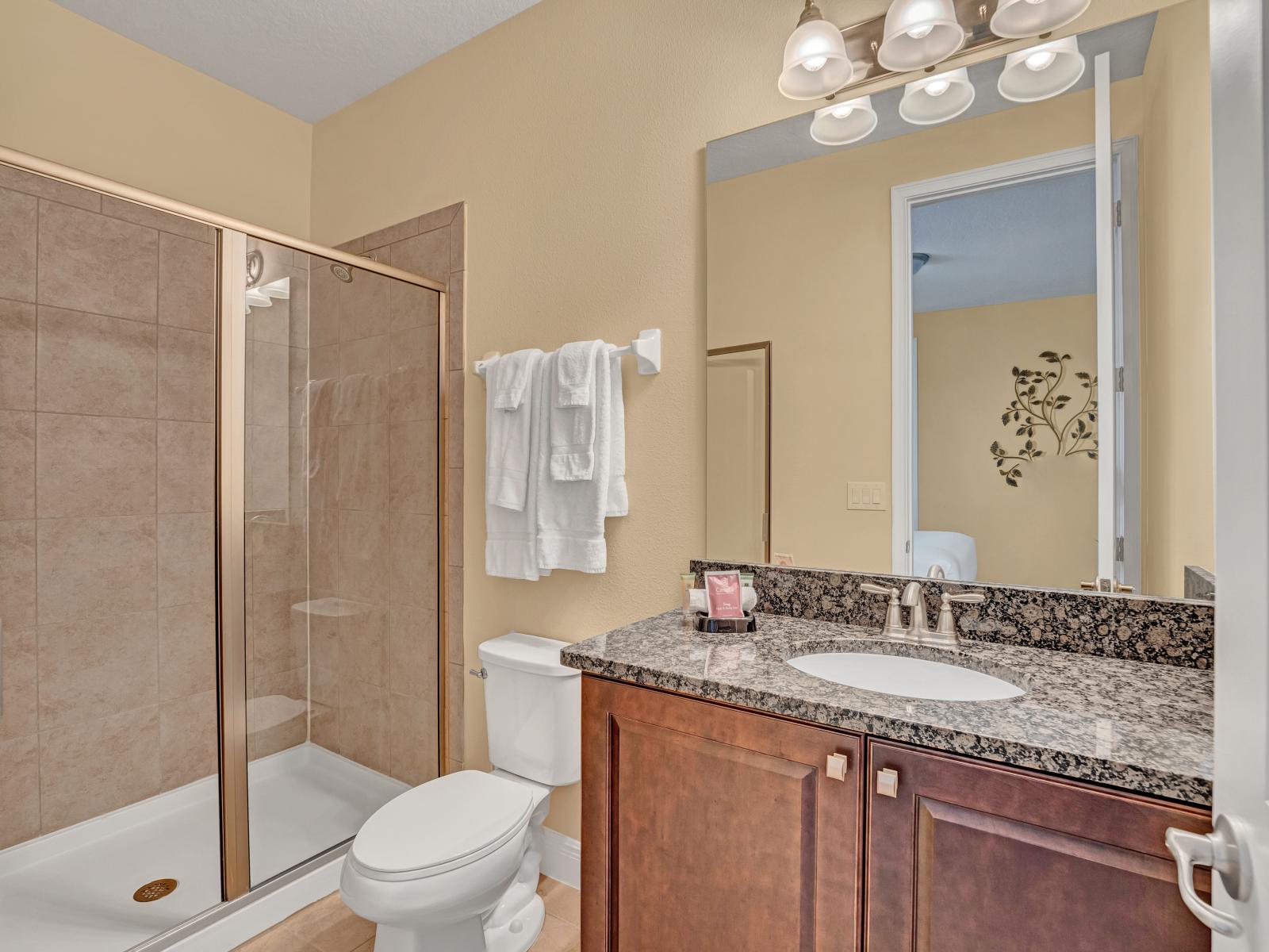 Lavish Bathroom of the Home in Kissimmee Florida - Neat and Clean - Spacious layout offering a sense of luxury and comfort - Glass-enclosed shower area - Polished Vanity with Large Mirror