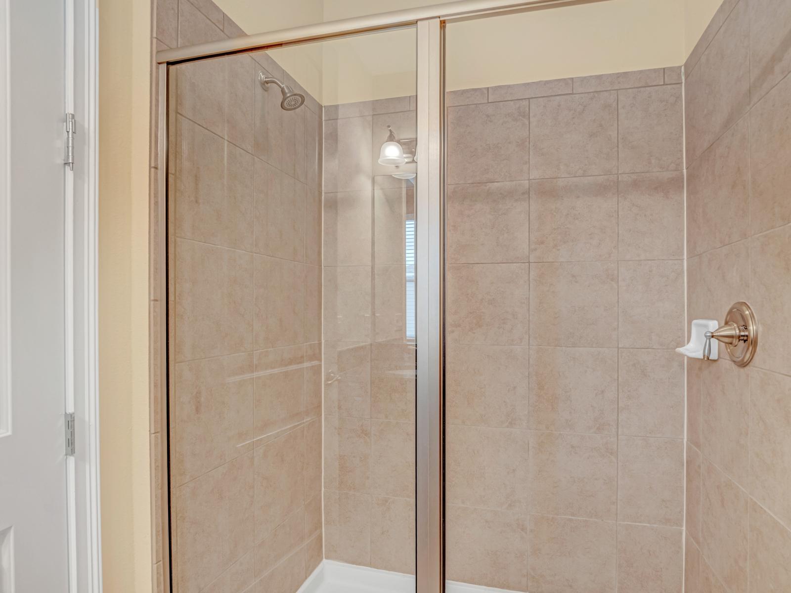 Deluxe Bathroom of the Home in Kissimmee Florida - Chic design featuring upscale lighting - Seamless design featuring a glass-enclosed shower - Spacious layout offering a sense of luxury and comfort