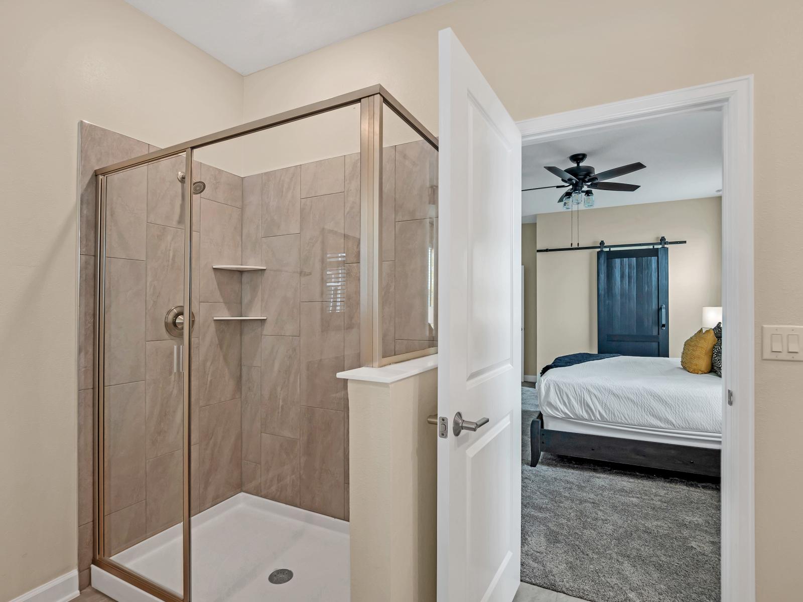 Lush Bathroom of the Home in Reunion Florida - Offers a luxurious bathing experience in an elegant setting - Glass-enclosed shower area