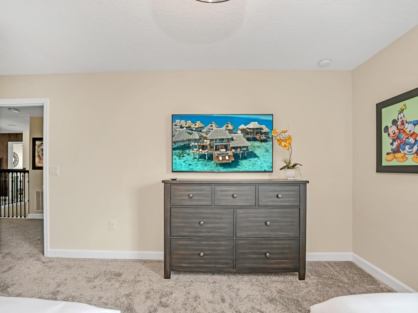 The bedroom's TV and wooden cabinet create a cozy entertainment nook.