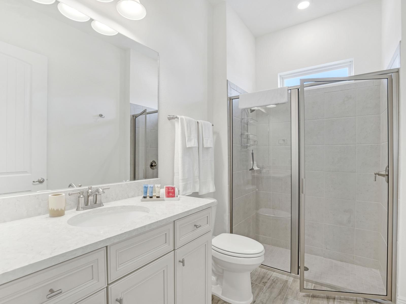 - Chic bathroom of the cottage in Florida - Indulge in elegance with all-white shower area and vanity space - Clean lines, pristine surfaces - plenty of light create a serene oasis