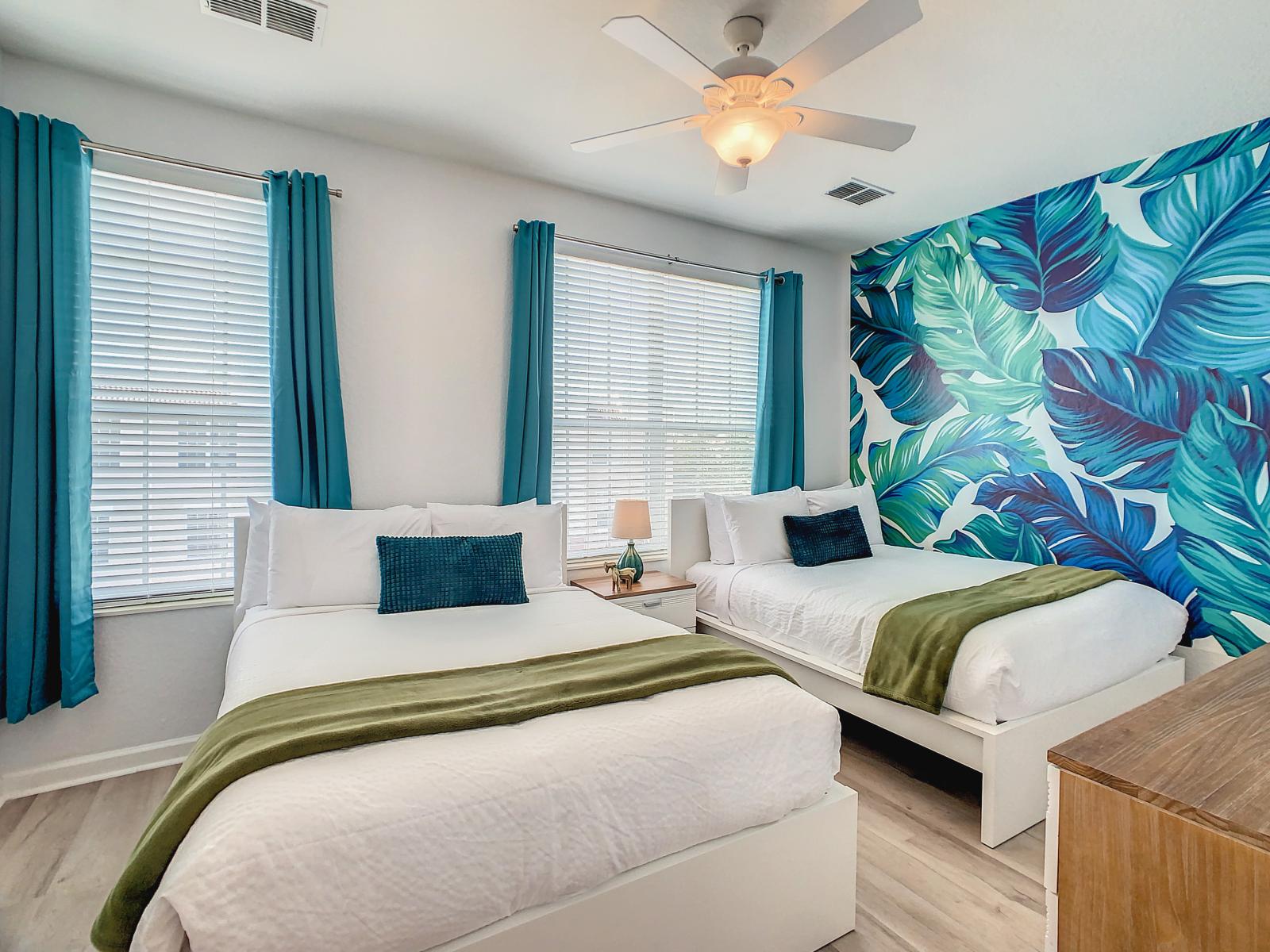 Relax in the inviting ambiance of the second bedroom, adorned with two full beds, creating a tranquil retreat reminiscent of a tropical paradise.