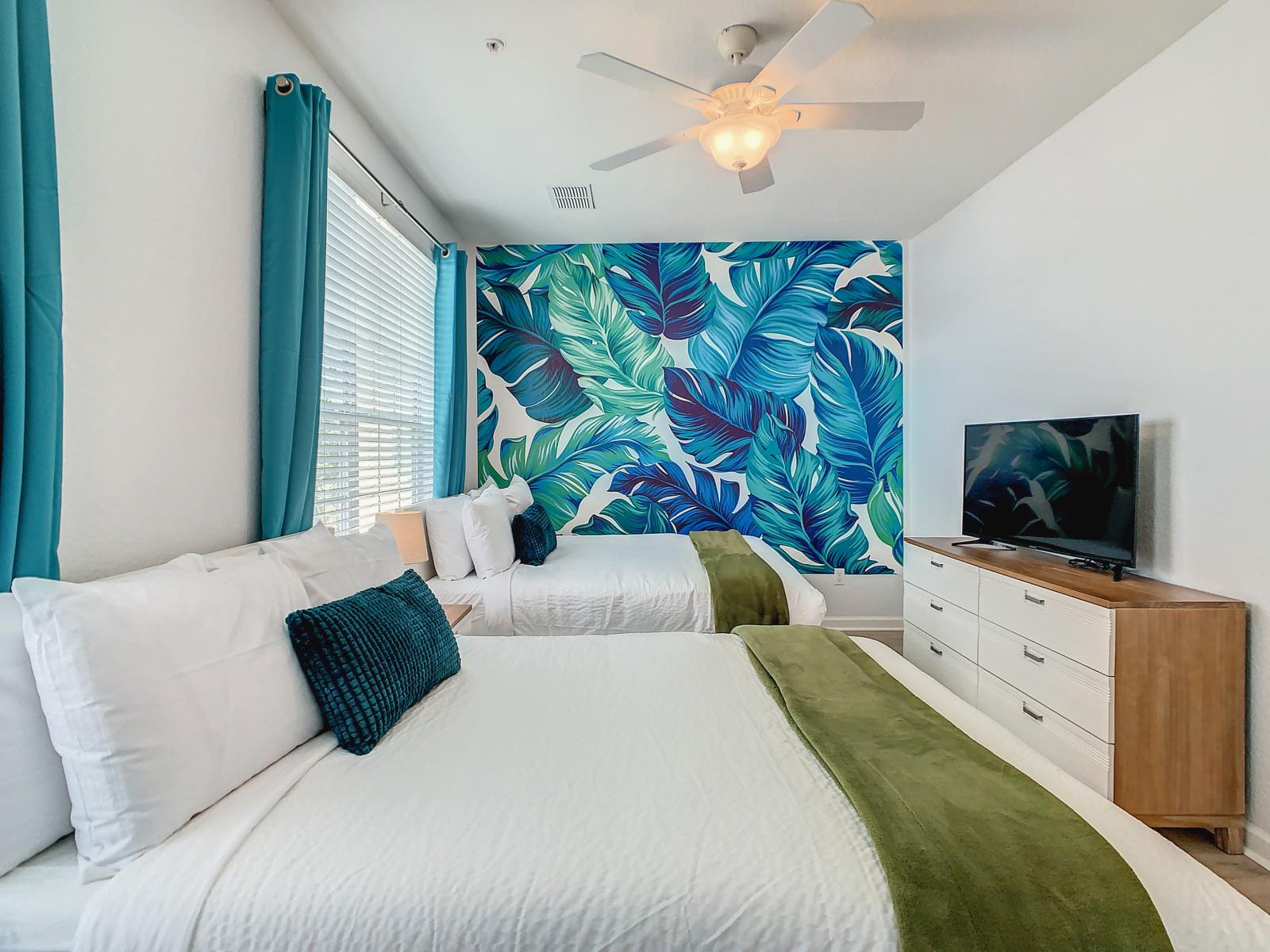 Experience the tropical ambiance of the second bedroom, complete with two full-size beds, offering a serene retreat for a restful night's sleep.