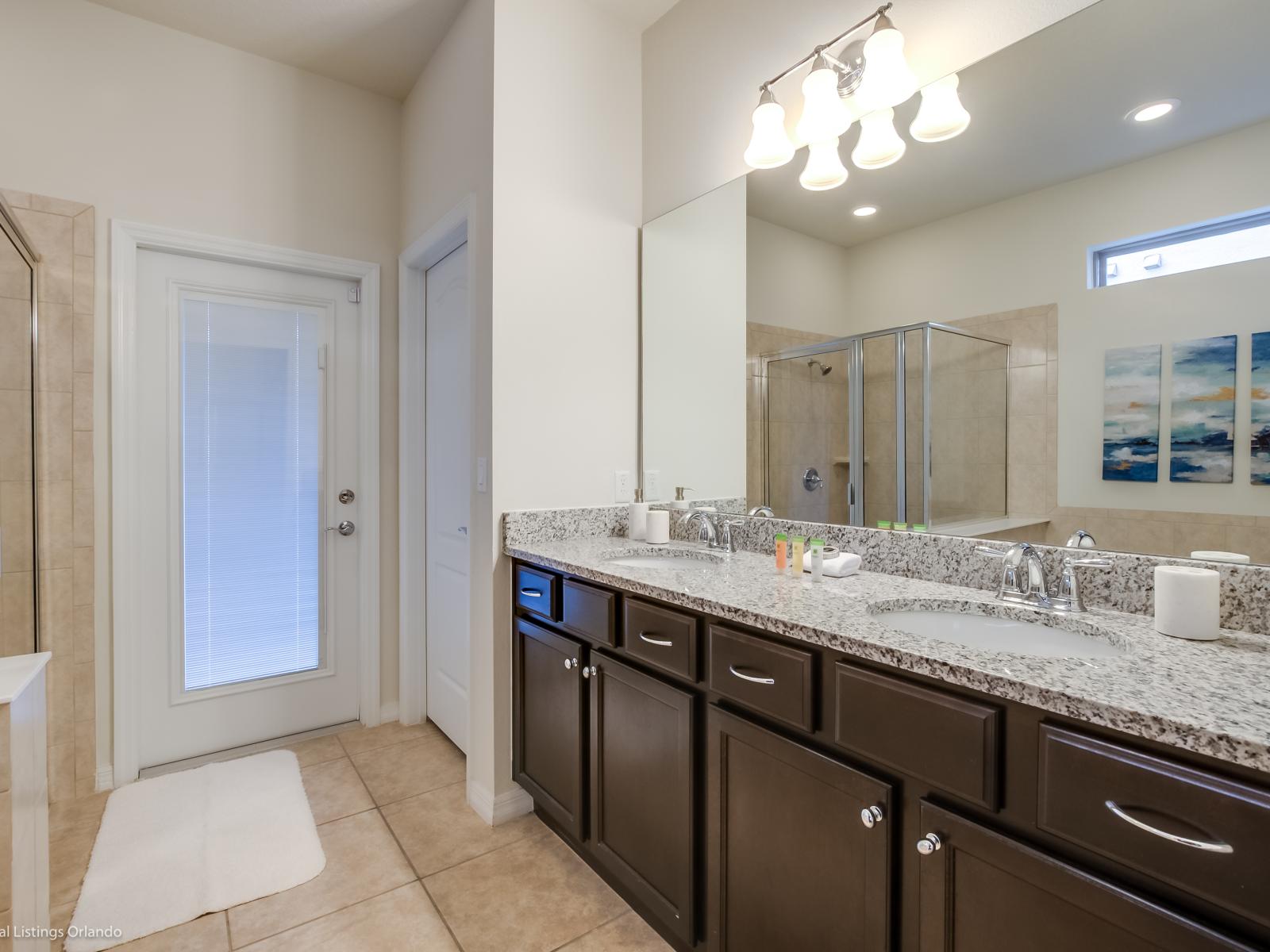 Behold the bathroom with its sleek shower enclosure and spacious vanity area. A contemporary retreat where convenience meets style, promising moments of rejuvenation and relaxation in a sleek and elegant space.