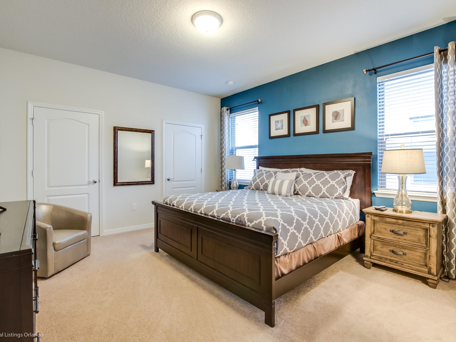 This bedroom is adorned with elegant decors and blue tone accent wall, creating a space that exudes refined serenity.