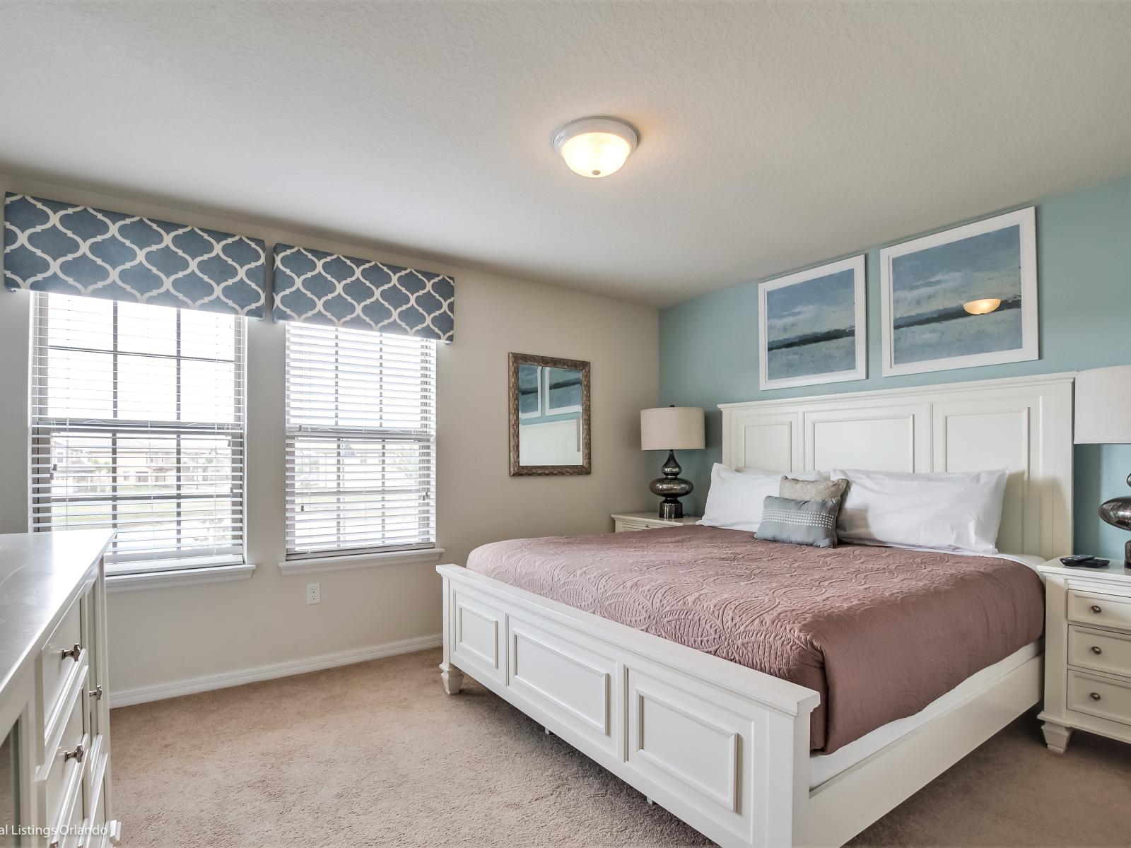 Step into the bedroom adorned with an accent mirror, flanked by side tables on each side adorned with elegant lamps. A space where thoughtful details converge, promising a serene ambiance and stylish comfort.