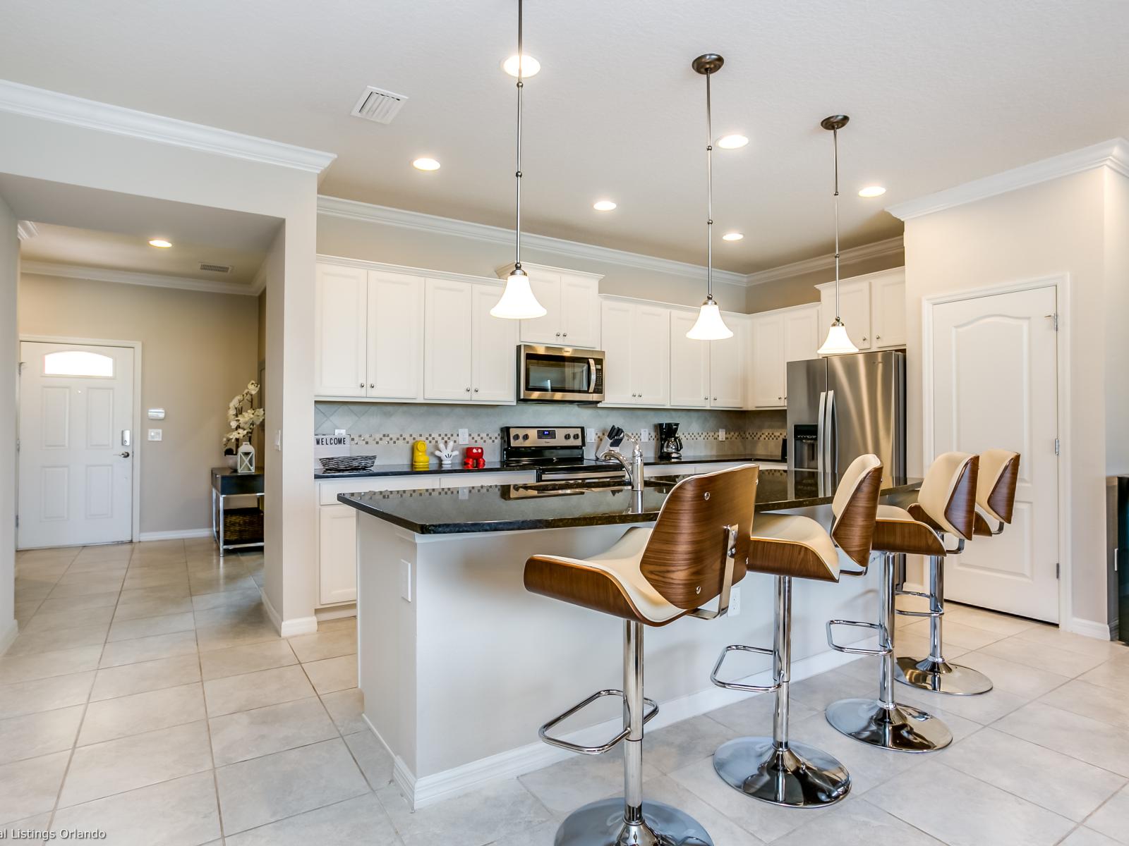 Modern kitchen of the townhouse in Kissimmee, Florida - Kitchen with stainless steel appliances  - Breakfast bar offers a convenient and casual dining space with counter-height chairs - Plenty of space to keep their belongings organized