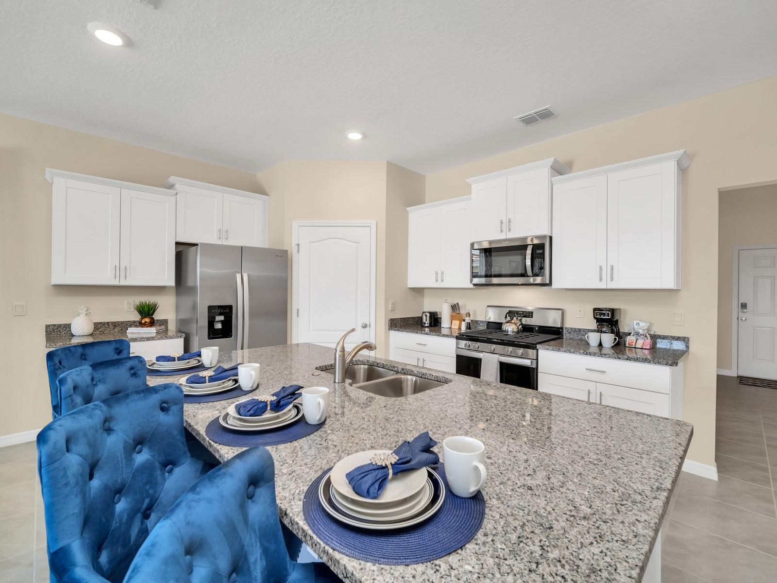 Sleek kitchen of the home in Florida -  Stainless steel appliances - Integrated appliances for a seamless and stylish appearance - Breakfast bar and high chairs - Thoughtful placement of kitchen essentials for easy access