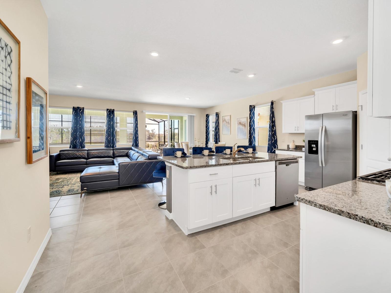 This cozy and sophisticated living room features a leather, wraparound sectional (and built-in chaise lounge), area rug with oceanic undertones, and wall-mounted flat-screen TV.