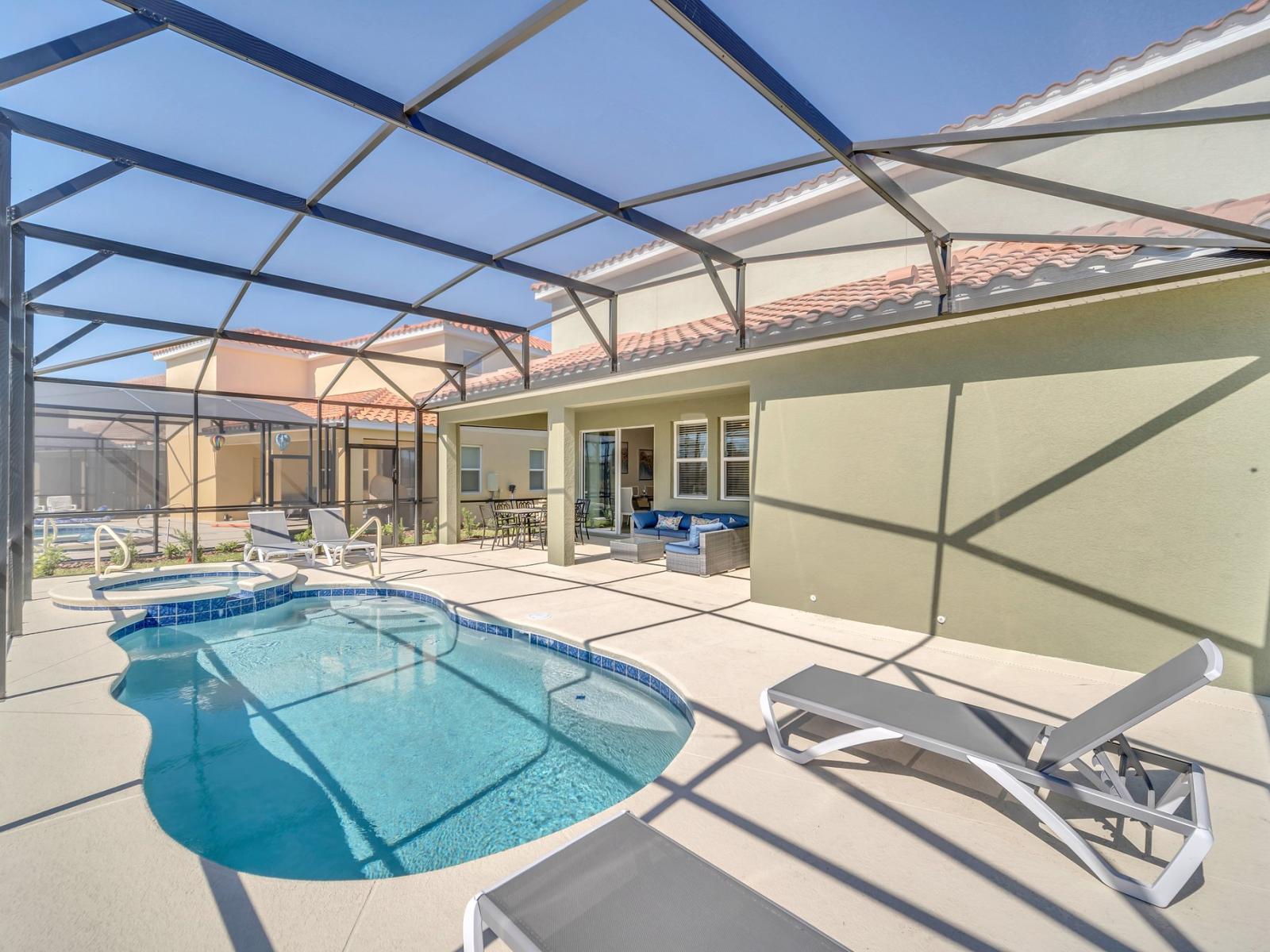 Inviting private screened-in lanai, perfect for entertaining and relaxing; complete with cozy patio furniture, a deluxe outdoor dining table, poolside lounge wear, and your very own spa and poo