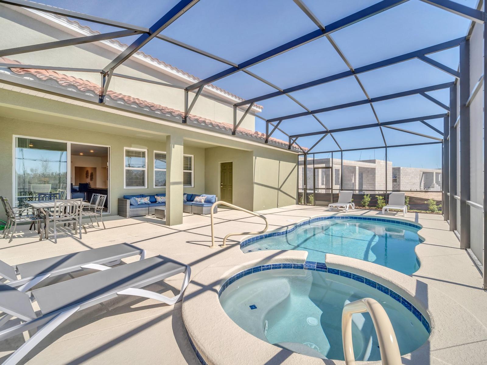 Discover the welcoming private screened-in lanai, an ideal space for entertaining and unwinding, equipped with cozy patio furnishings, a deluxe outdoor dining arrangement, poolside loungewear, and exclusive access to your spa and pool.