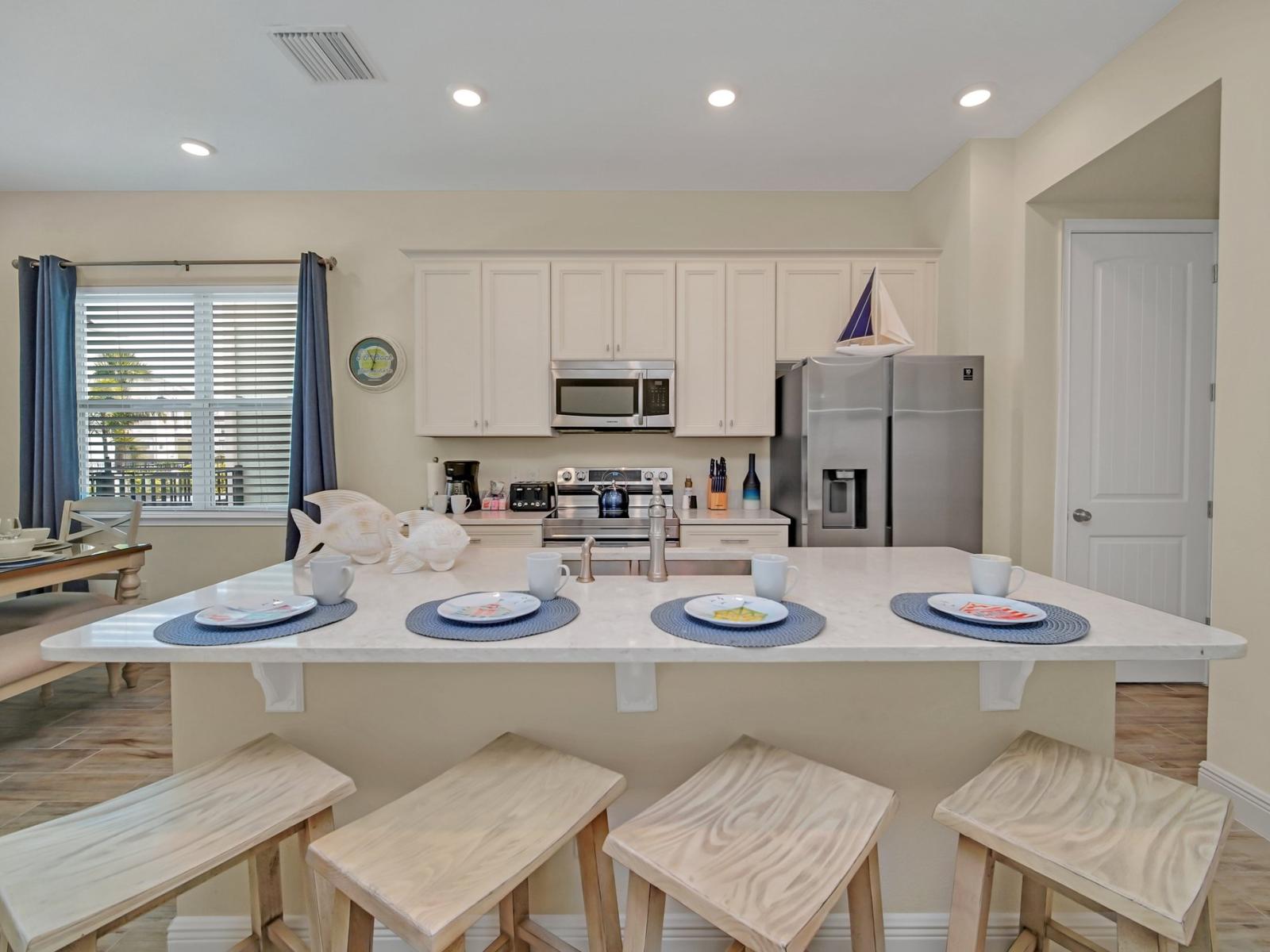 - Polished kitchen of the cottage in Reunion Florida - Sleek stainless steel appliances - Integrated appliances for a seamless and stylish appearance - Breakfast bar with high chairs