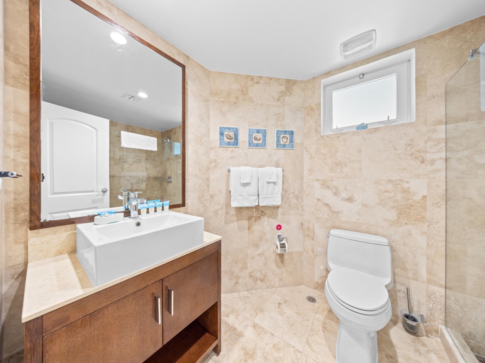 Luxuriate in our main bathroom featuring a sleek walk-in shower. Experience comfort and style in every detail of your rejuvenating retreat.