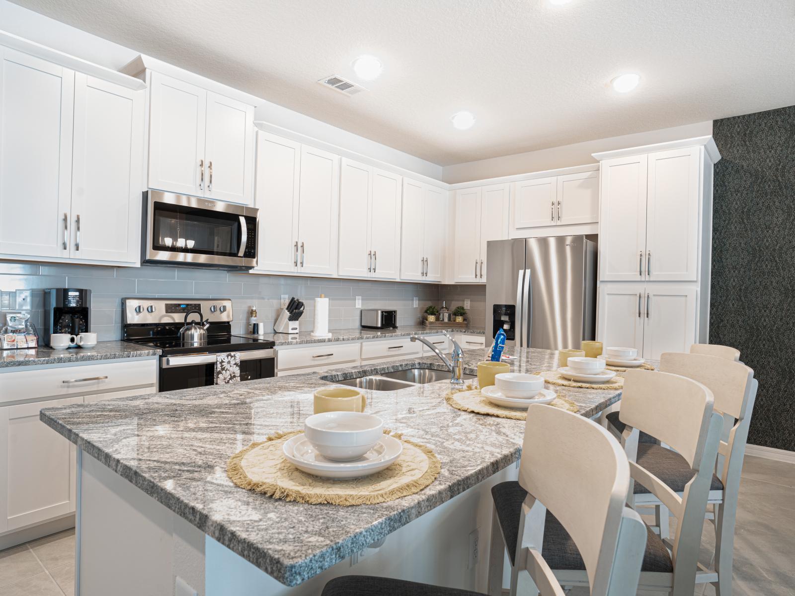 This fully equipped kitchen features modern appliances and barstools at the counter area, allowing you to prepare delicious meals and snacks with ease.