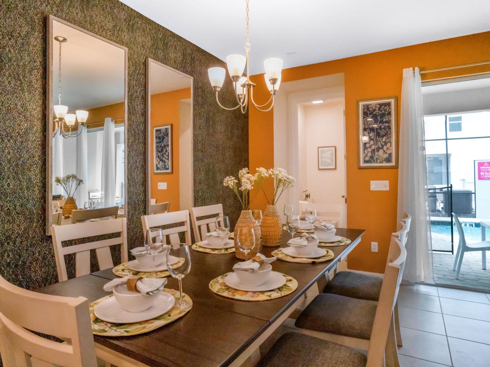 Sophisticated dining area of the townhouse in Four Corners Florida - Dining arrangement for 8 persons - Thoughtful lighting fixtures creating an intimate and inviting atmosphere - Understated elegance with a focus on clean lines and sleek design