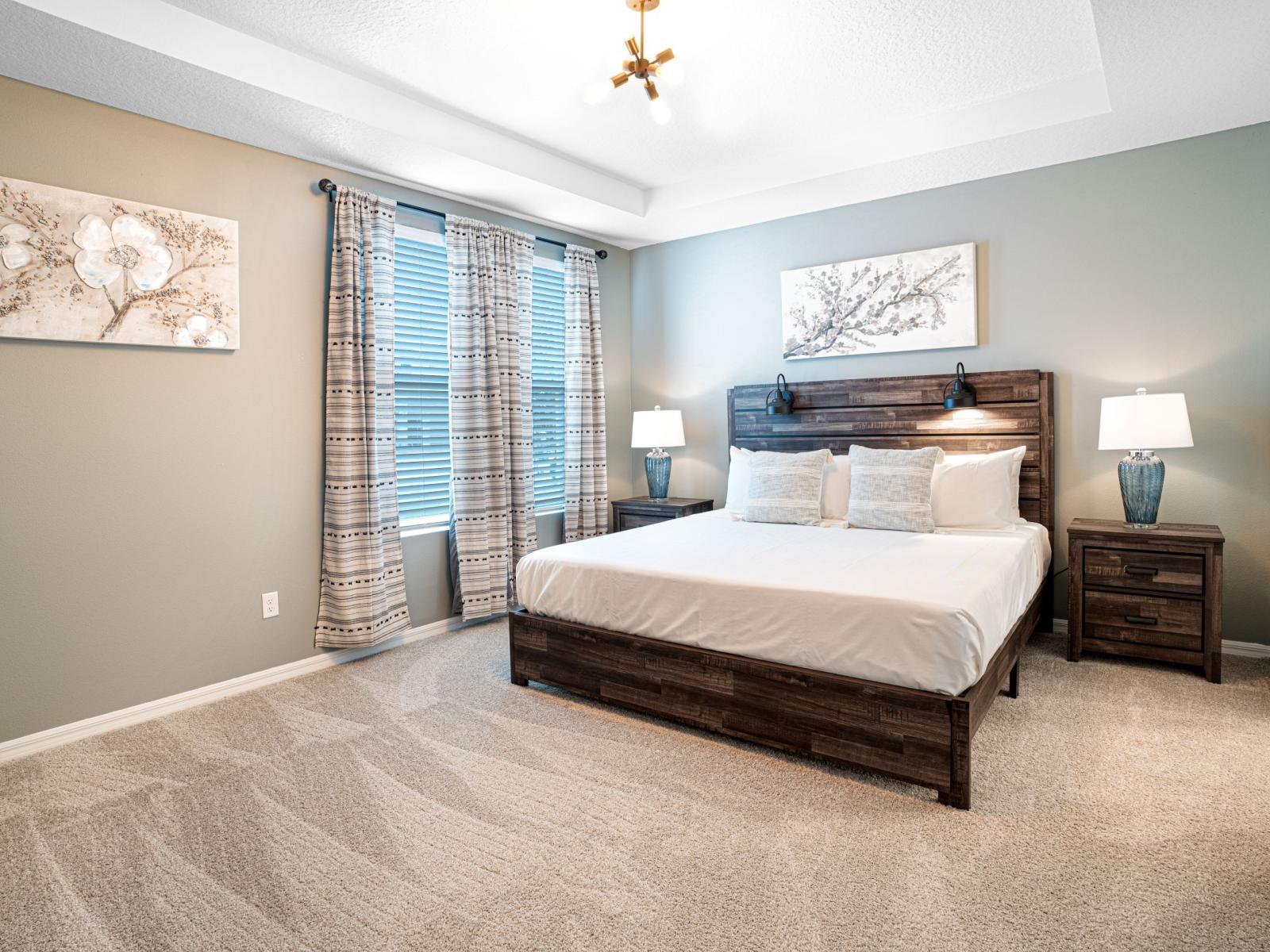 The second bedroom is a strikingly refined yet inviting boudoir, offering a queen size bed with a modern tufted headboard and high-profile base set upon a stately frame.