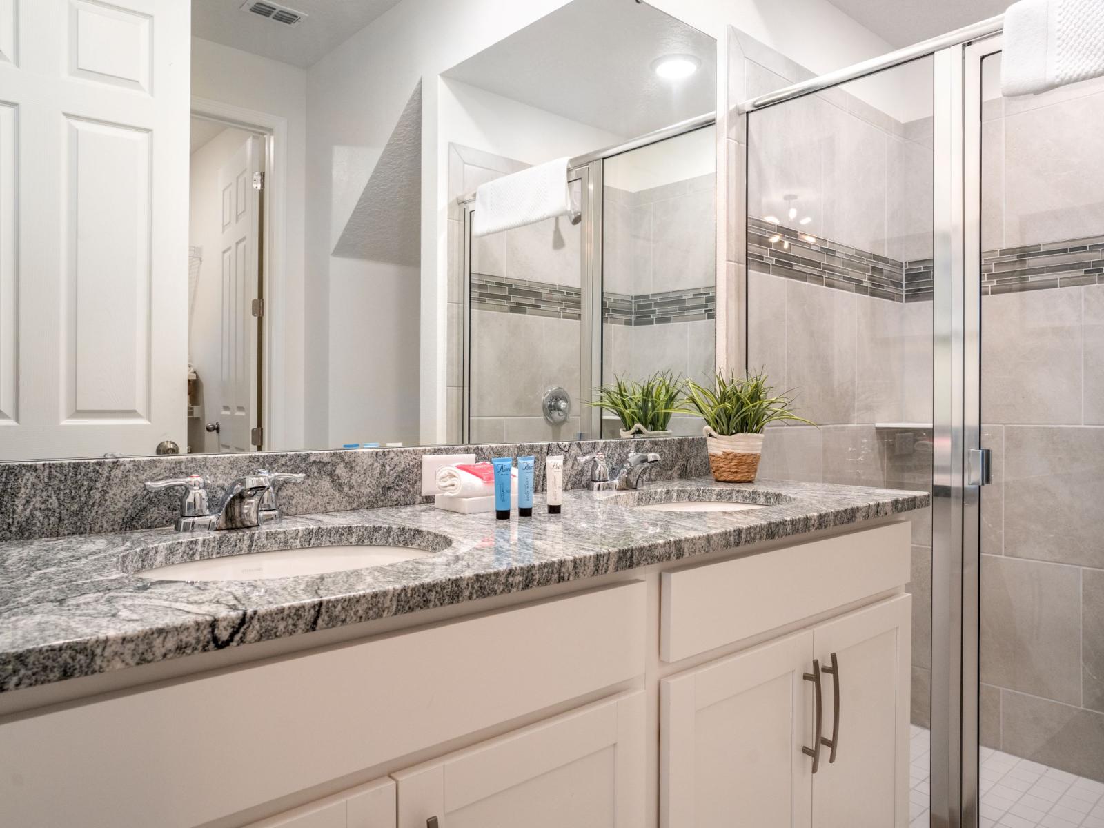 Chic bathroom of the townhouse in Four Corners Florida - Effortlessly stylish double vanity and chic accessories - Large size mirror - Walk-in shower spacious area