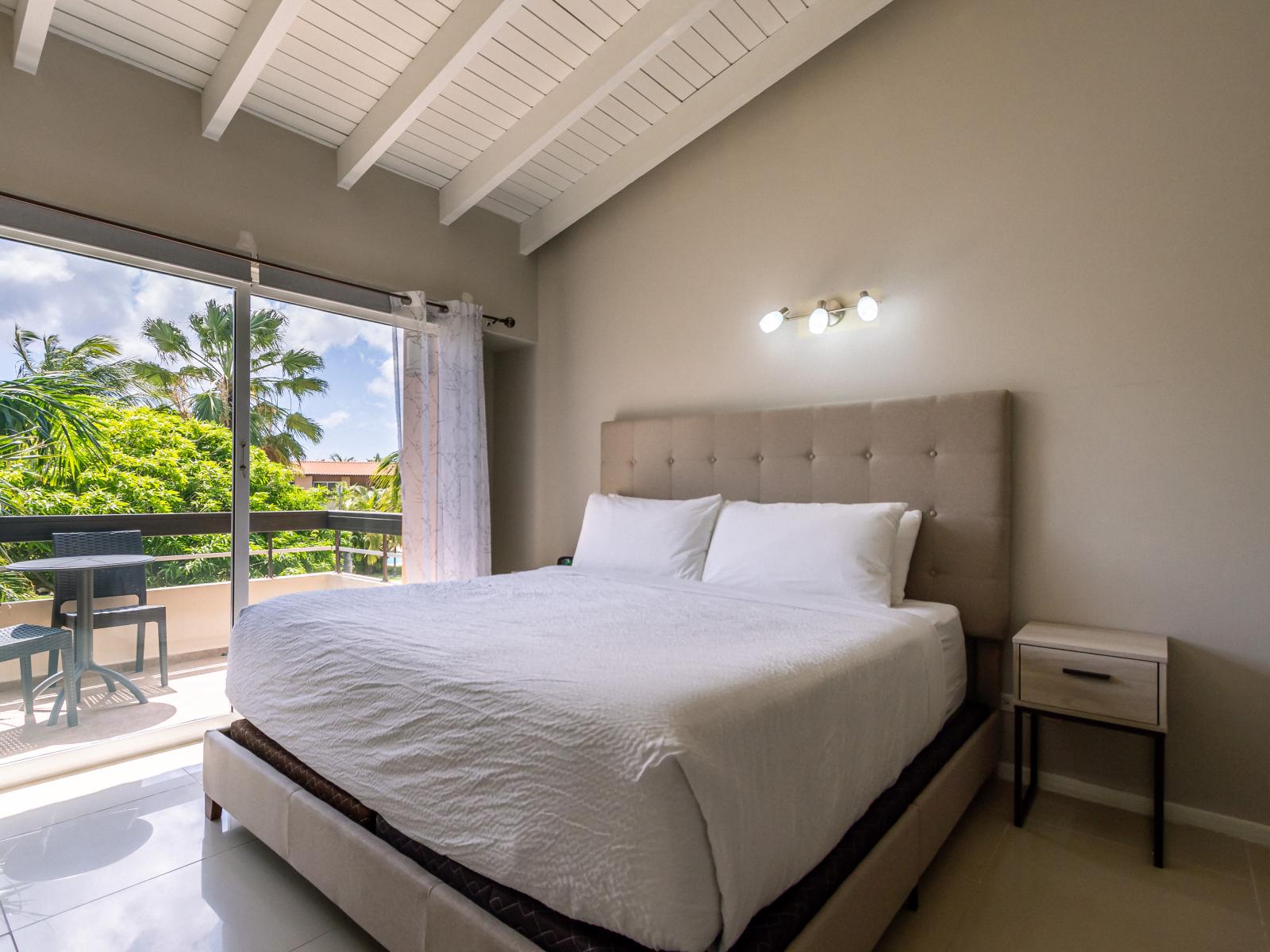 Deluxe Bedroom of the 3BR Condo in Oranjestad Aruba - King size comfy Bed - Minimalist decor, creating a clean and uncluttered sleeping space - Private Balcony - Outstanding outside Views