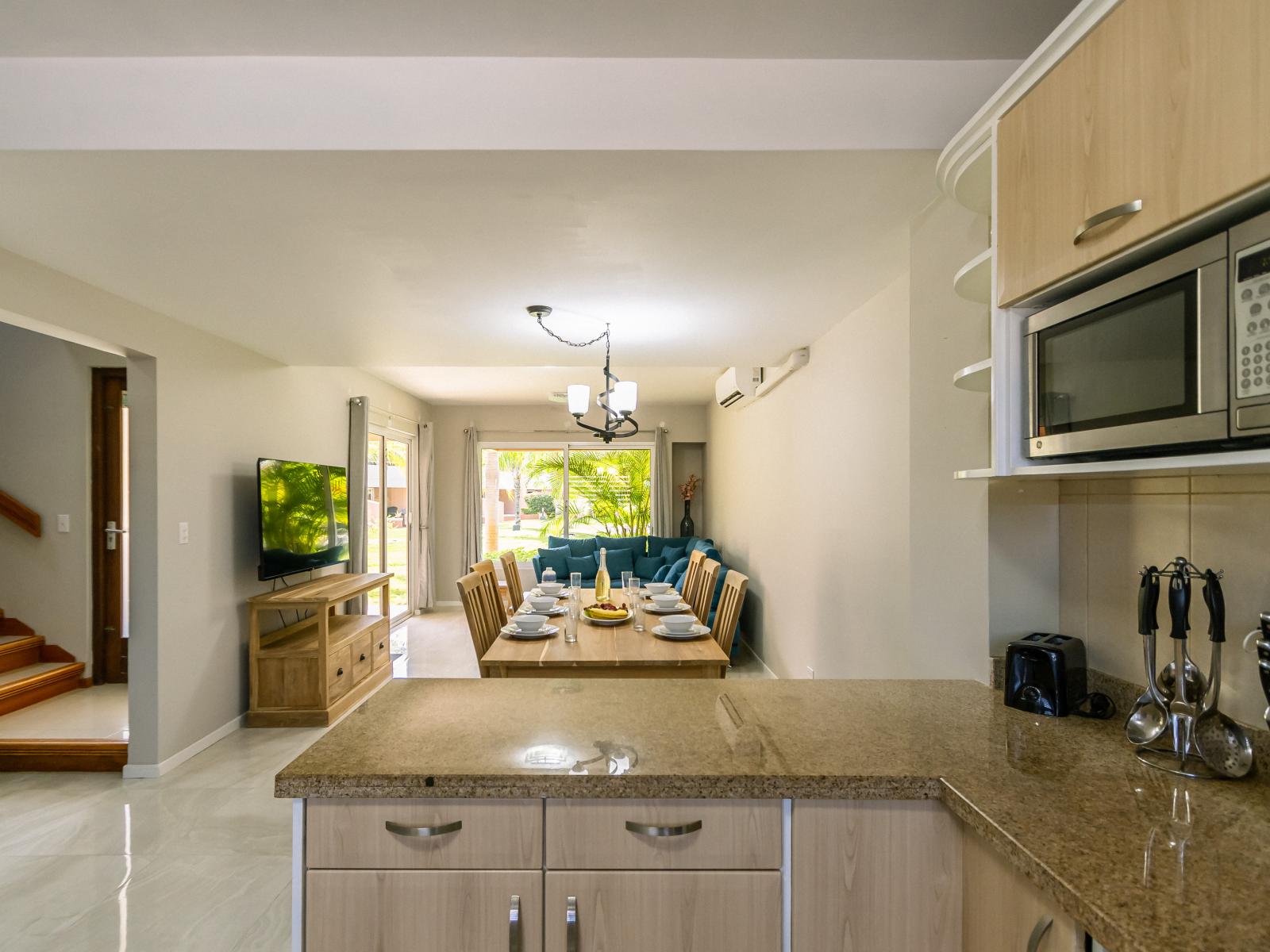 Luxurious Dining and Living Area of the 3BR Condo in Oranjestad Aruba - Plush and comfortable seating arrangements - Ample natural light through large windows - Stunning outside garden views - Smart TV and Netflix