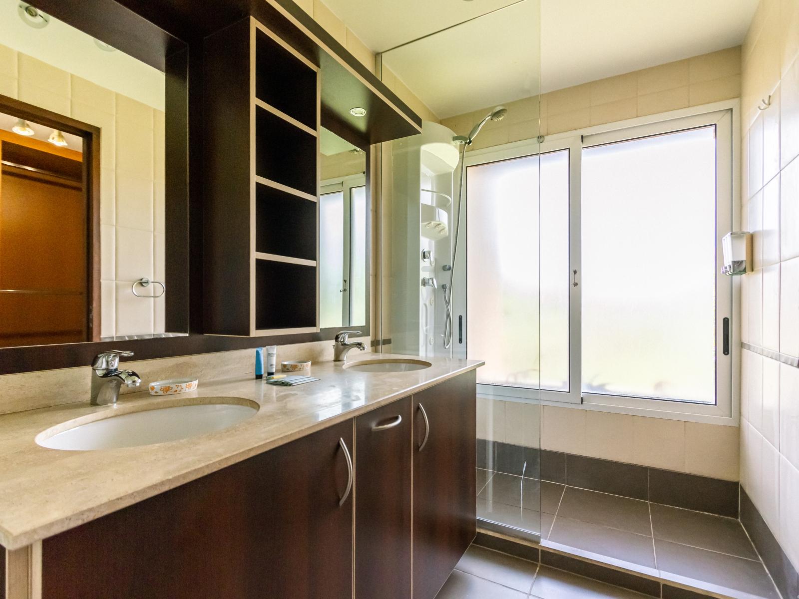 Enjoy the spacious main bathroom with dual sinks and a walk-in shower, designed for comfort and style.