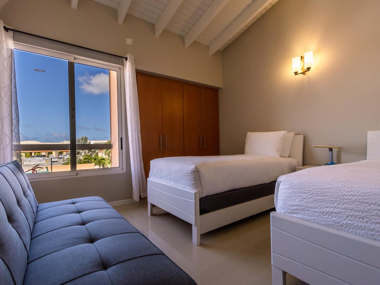 Eclat Bedroom of the 3BR Condo in Oranjestad Aruba - Comfy Twin Bed - Large windows with lush outside views - Comfy sofas