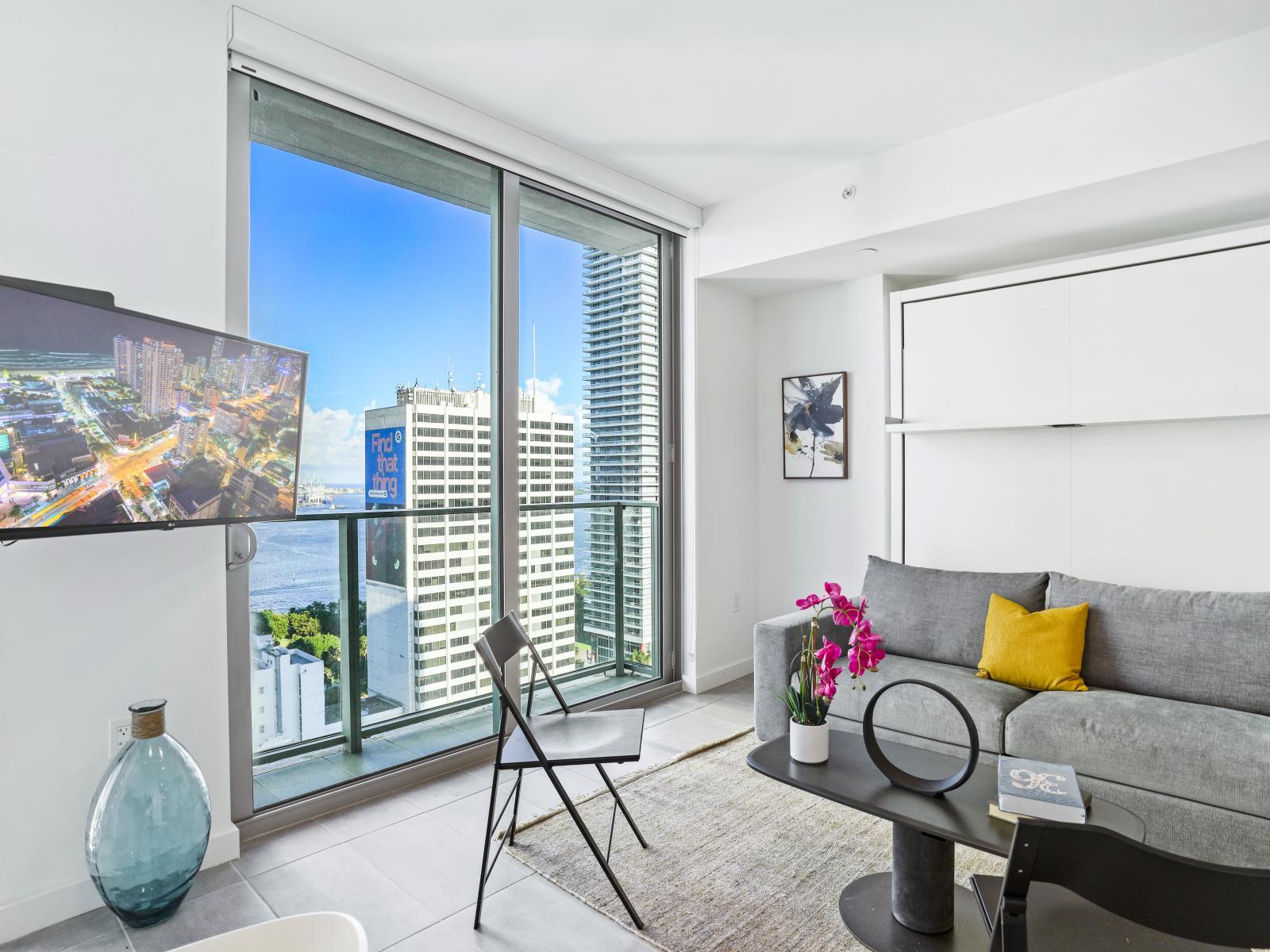 Living/sleeping area w/ view of Biscayne Bay Port - This cozy living space is perfect for family movie nights and lazy weekends. The large windows afford you panoramic views of the city.