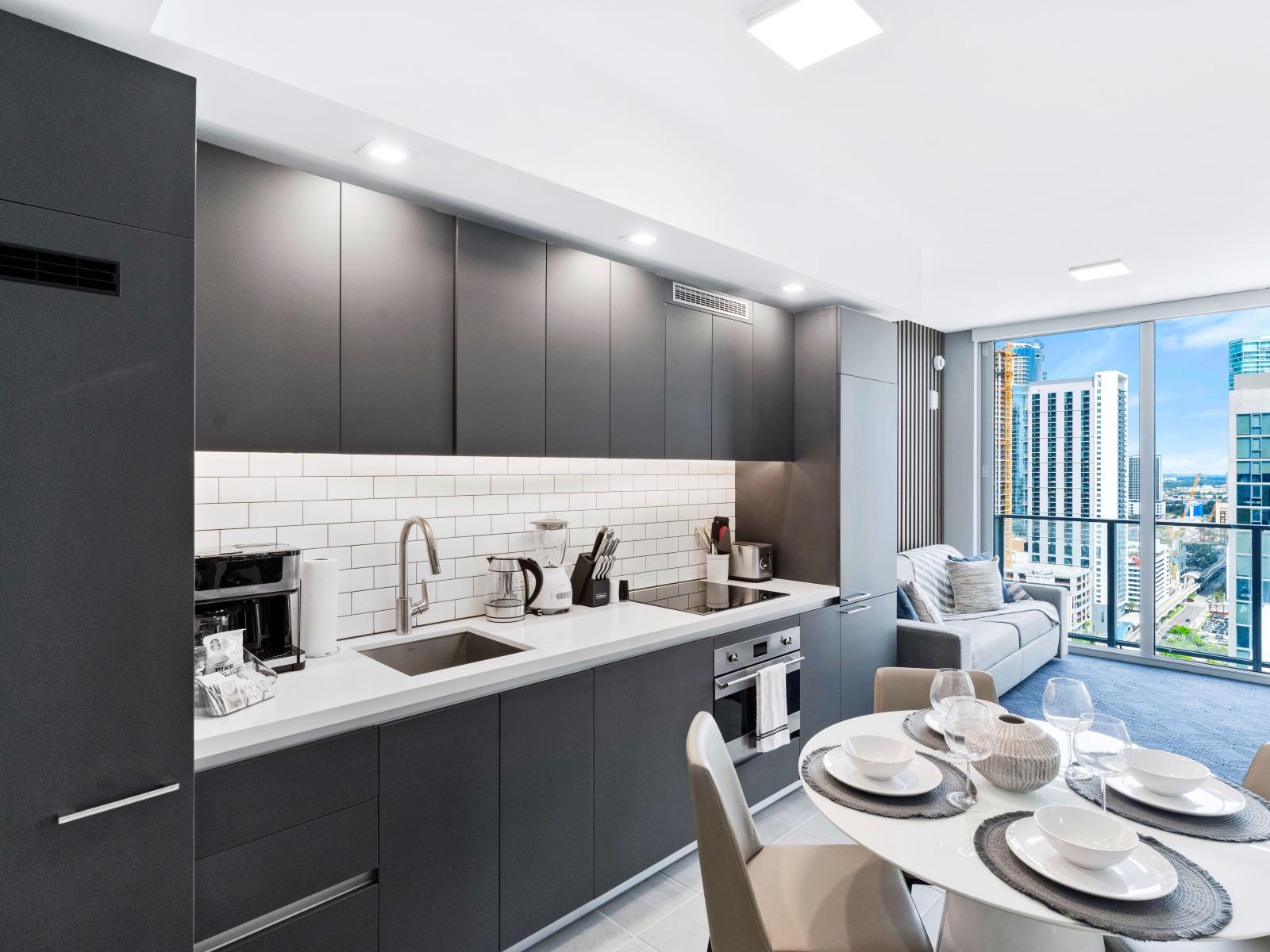 Fully equipped kitchen and dining area - Contemporary fully equipped kitchen with stainless steel appliances, a coffee maker, dishwasher, easy to use amenities and a dining table with seating for four.